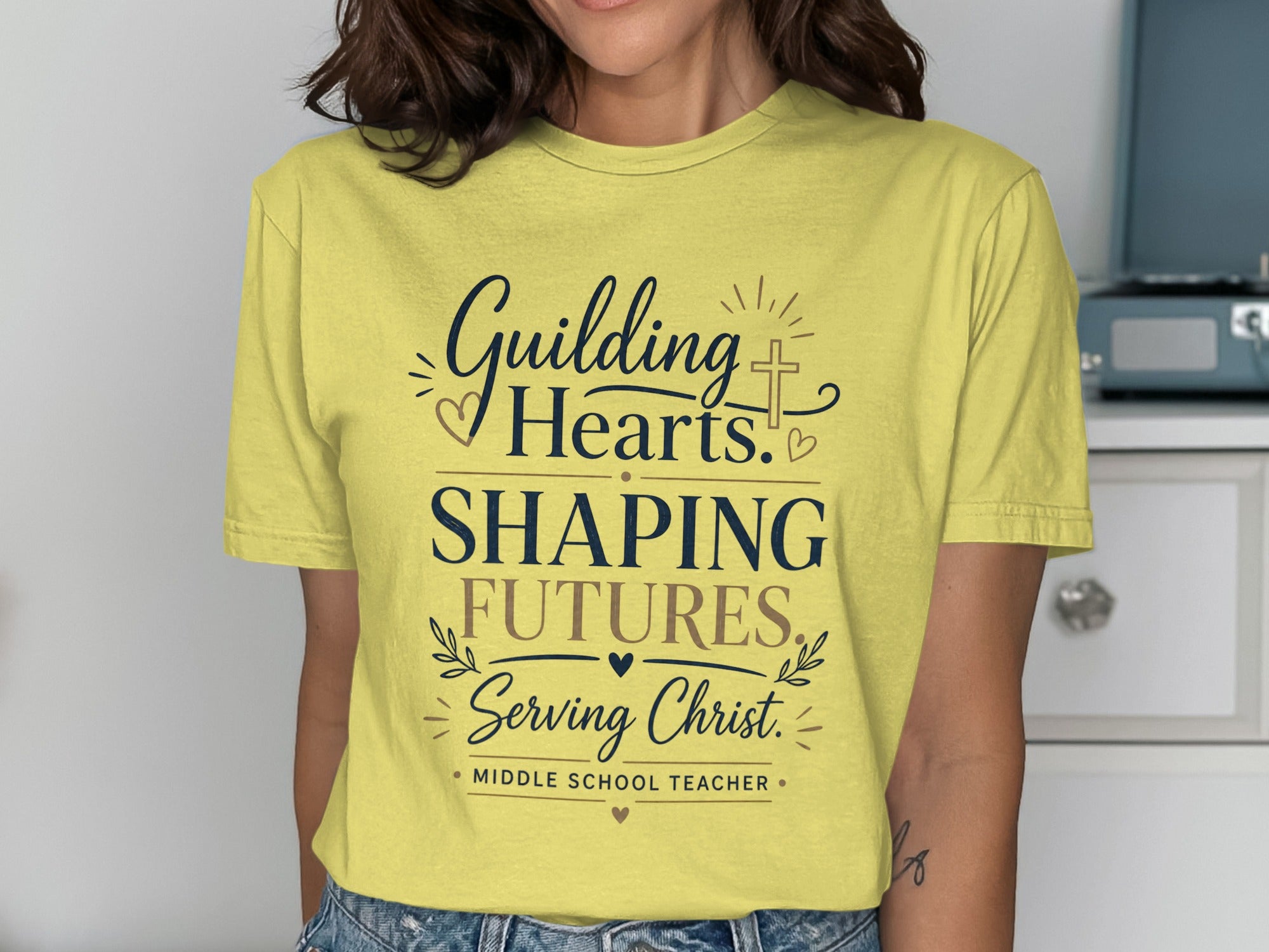 Yellow t-shirt with "Guiding Hearts, Shaping Futures, Serving Christ. Middle School Teacher." text.