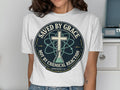 T-shirt with "Saved by Grace" text, cross, and atom symbol.