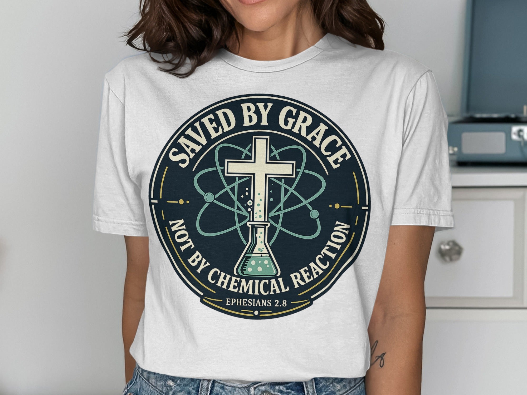 T-shirt with "Saved by Grace" text, cross, and atom symbol.