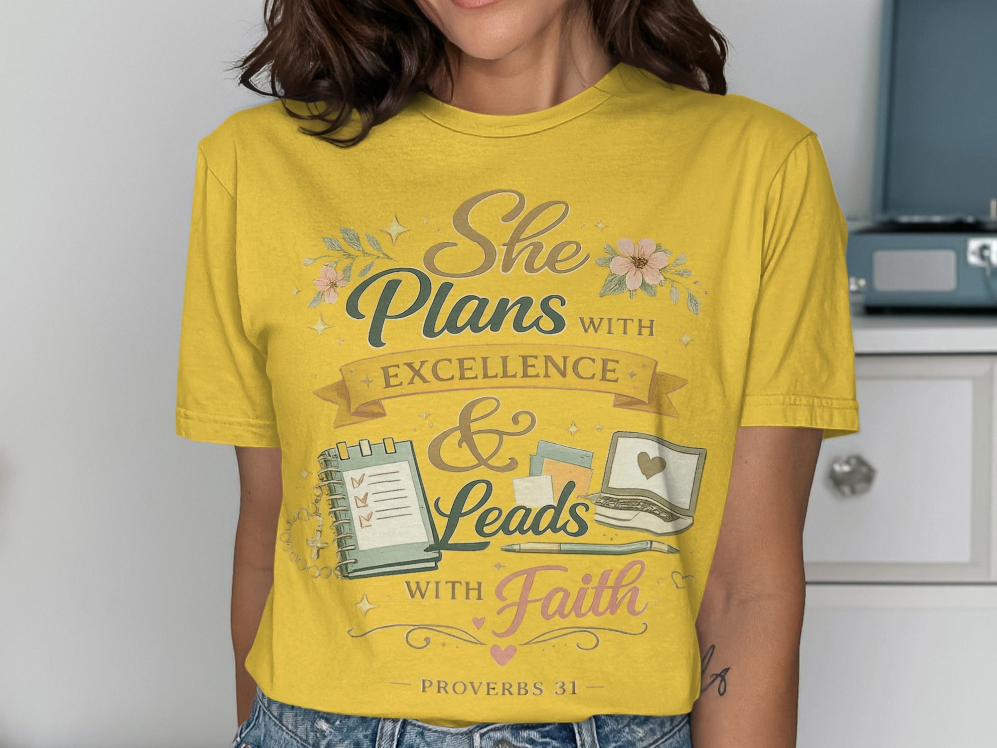 Yellow t-shirt with "She Plans with Excellence & Leads with Faith" text.