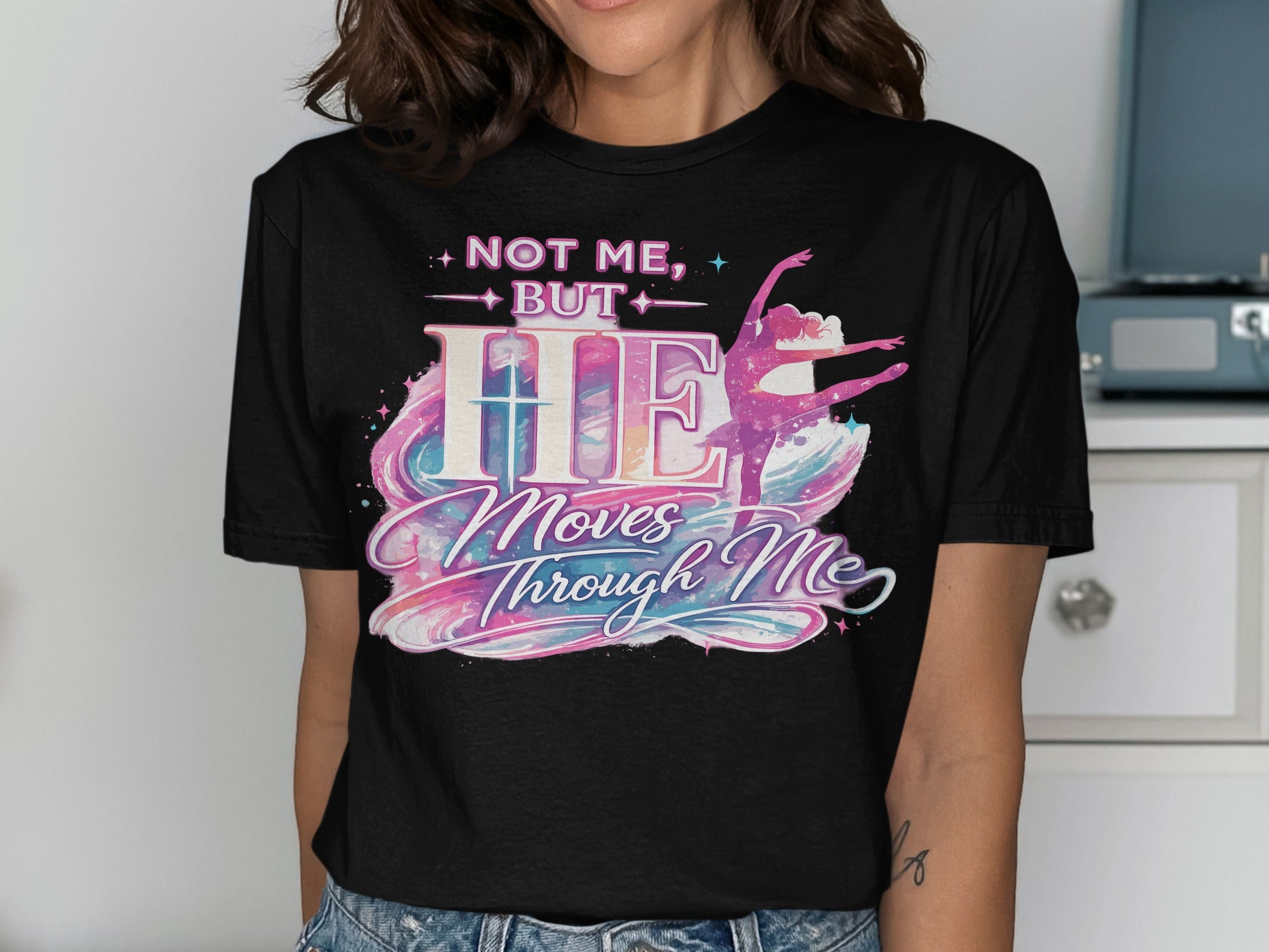 Black t-shirt with "NOT ME, BUT HE Moves Through Me" and a ballet dancer.