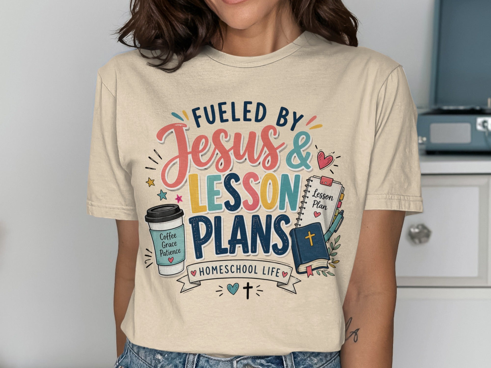 Beige t-shirt with "Fueled by Jesus & Lesson Plans" and homeschool icons.