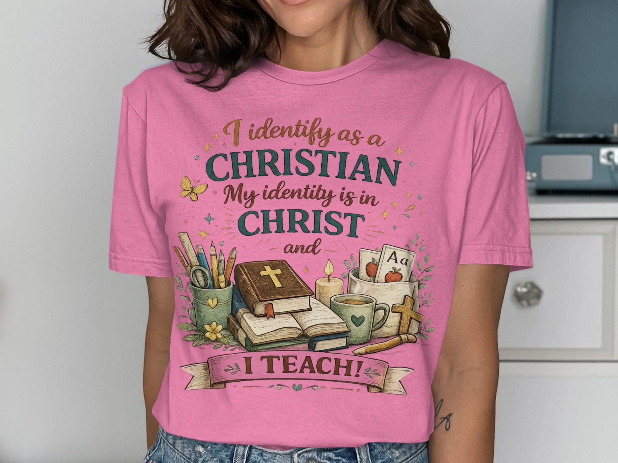Pink t-shirt with text and Christian symbols, including "I TEACH!".