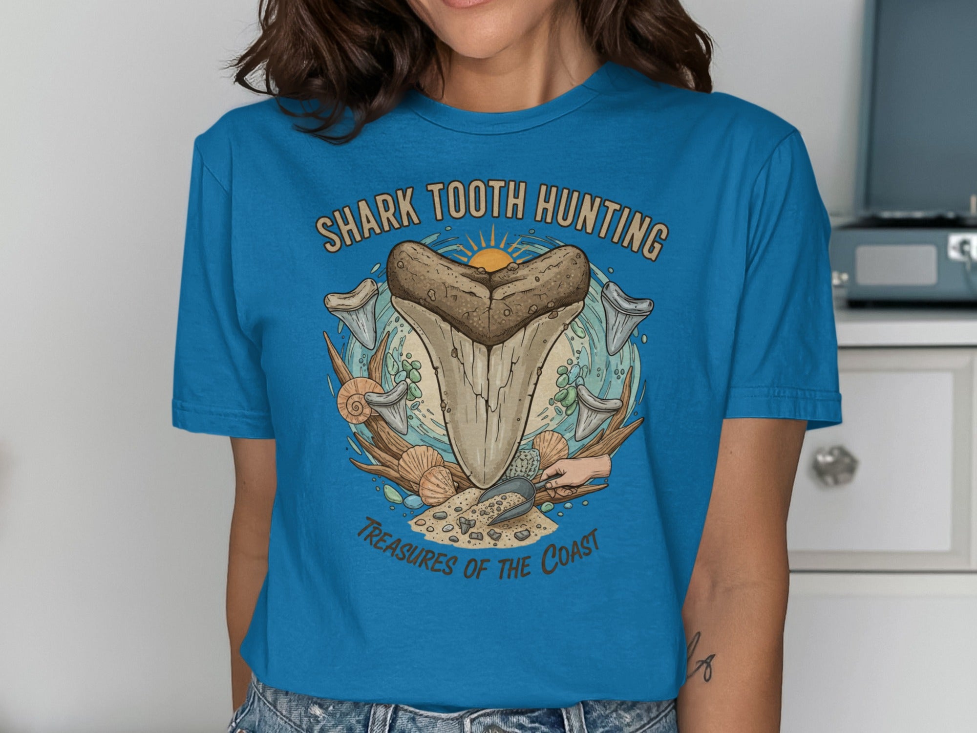 Shark tooth hunting treasures of the coast graphic with large tooth, shells, and shovels.