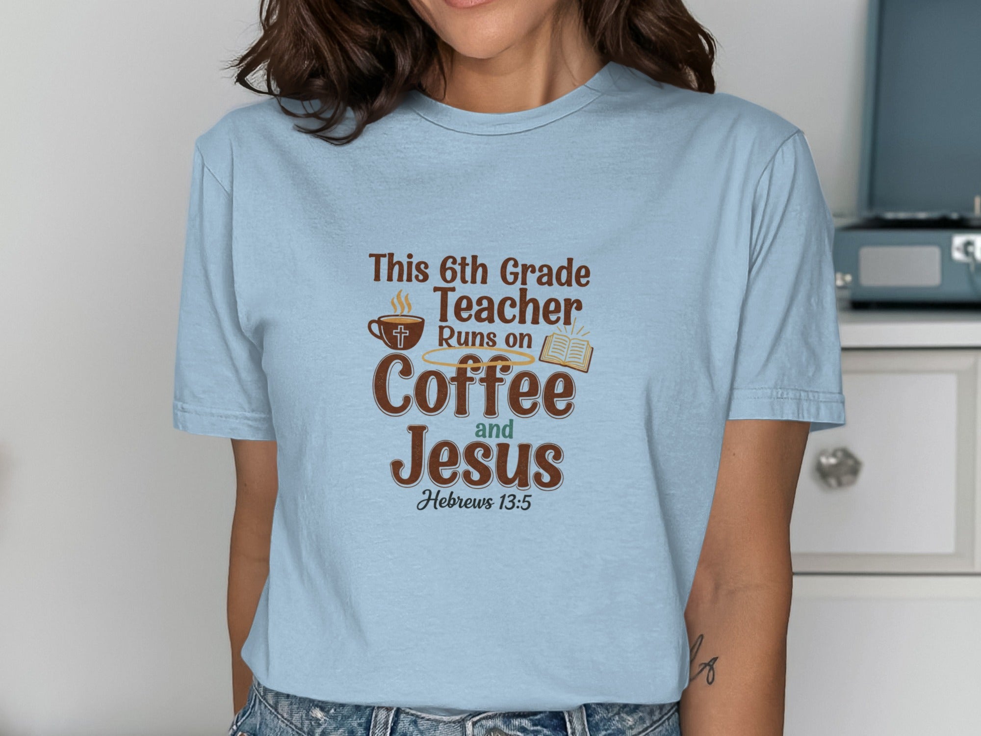 Light blue t-shirt with "This 6th Grade Teacher Runs on Coffee and Jesus" text.