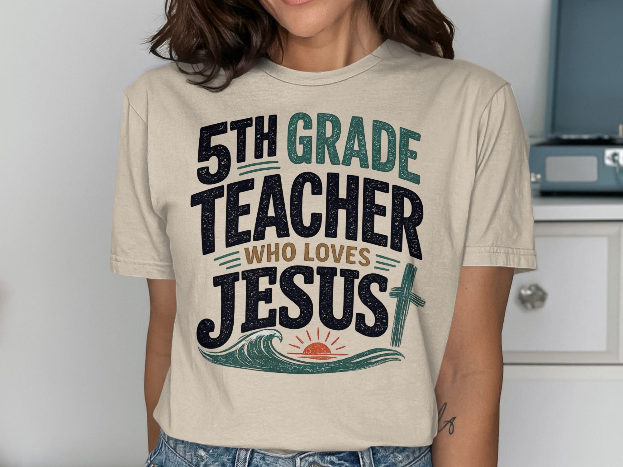 5th Grade Teacher Who Loves Jesus t-shirt with waves and sun graphic.