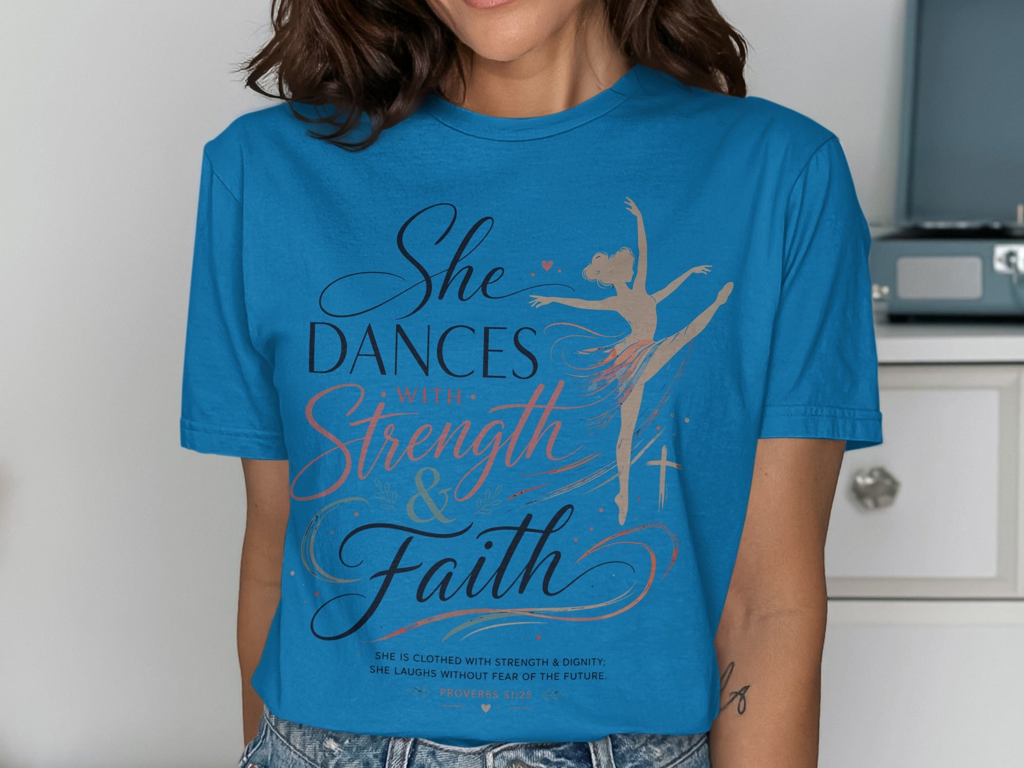 Blue t-shirt with "She Dances with Strength & Faith" and Proverbs 31:25.