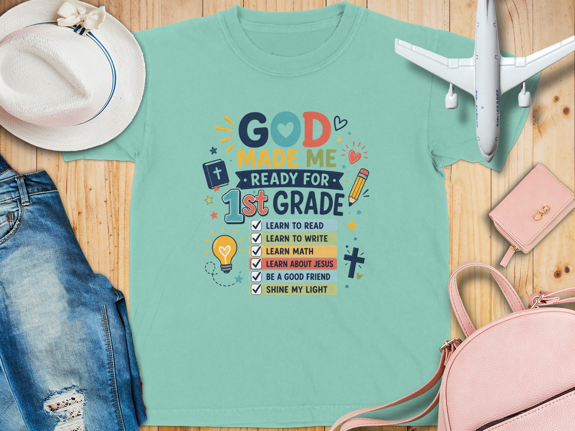 Mint green t-shirt with "God made me ready for 1st grade" text.
