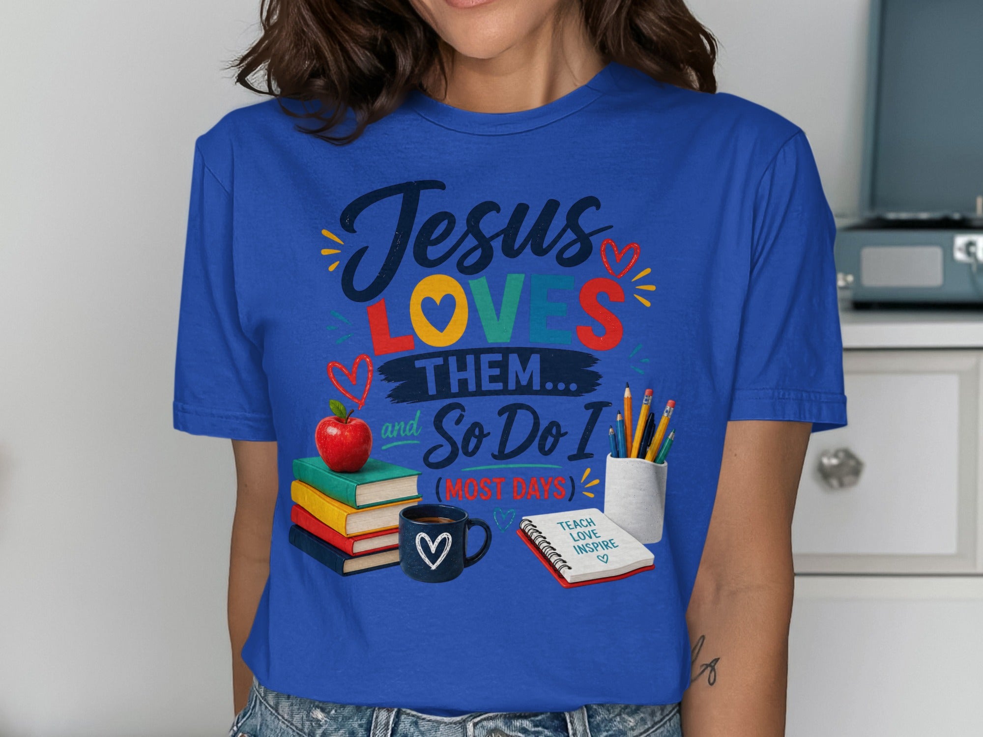Blue t-shirt with "Jesus Loves Them... So Do I (Most Days)" and teaching icons.