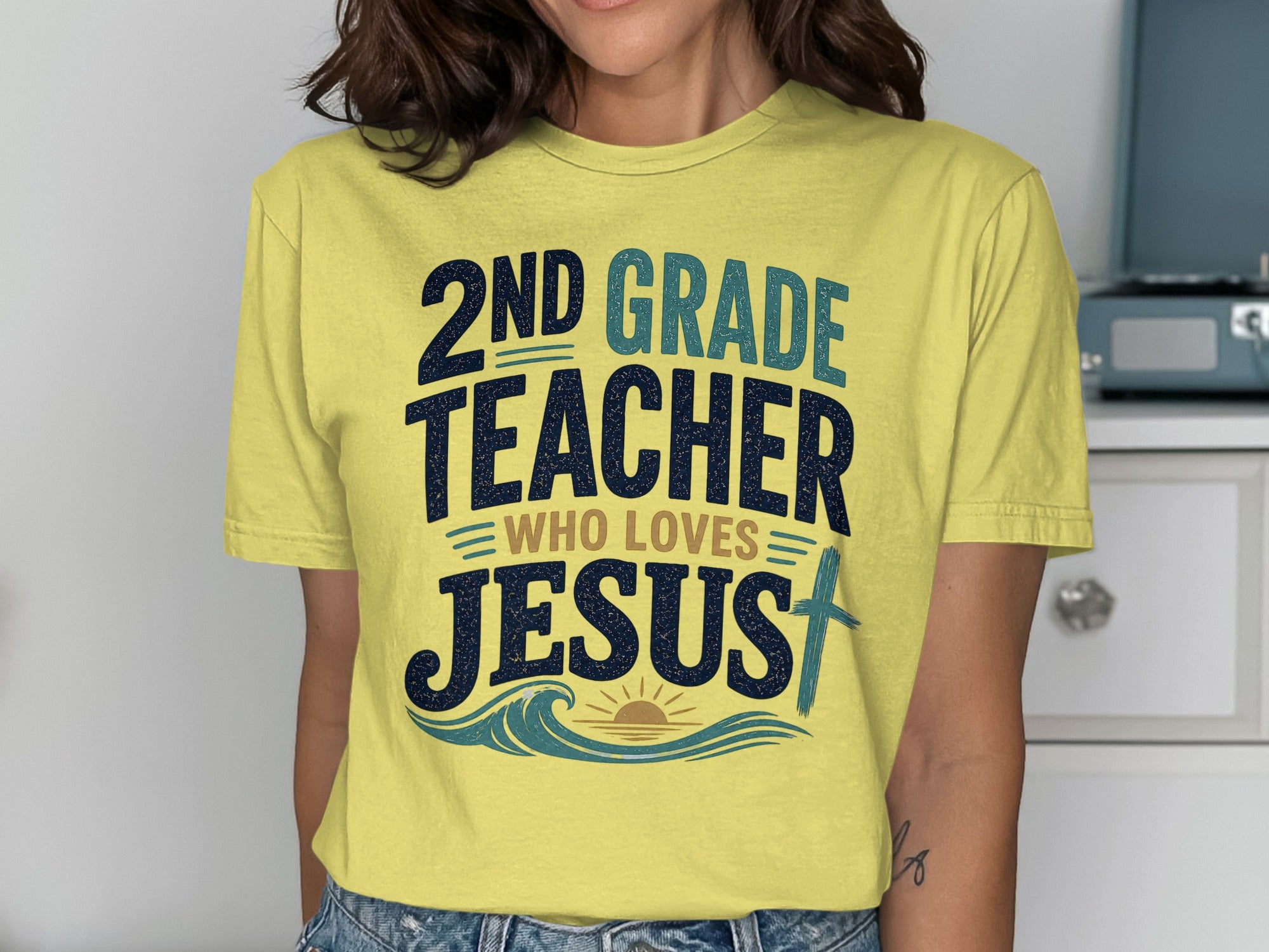 Yellow t-shirt with text "2nd Grade Teacher Who Loves Jesus" and a cross.