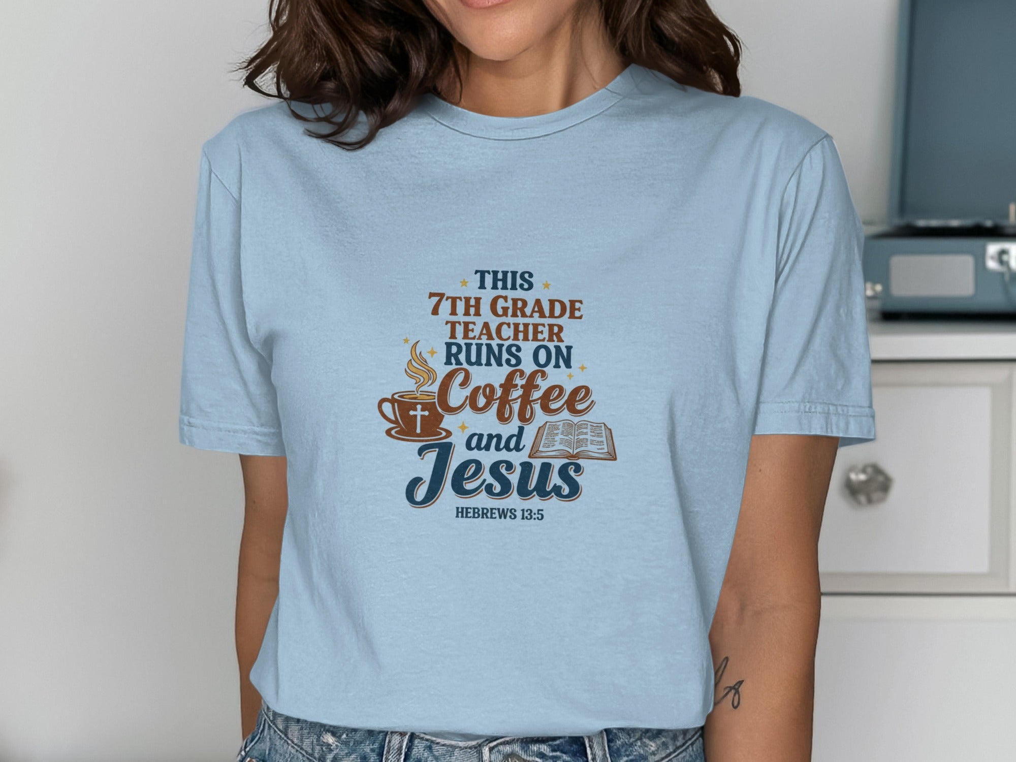 Light blue t-shirt with "This 7th Grade Teacher Runs on Coffee and Jesus" text and Bible verse.