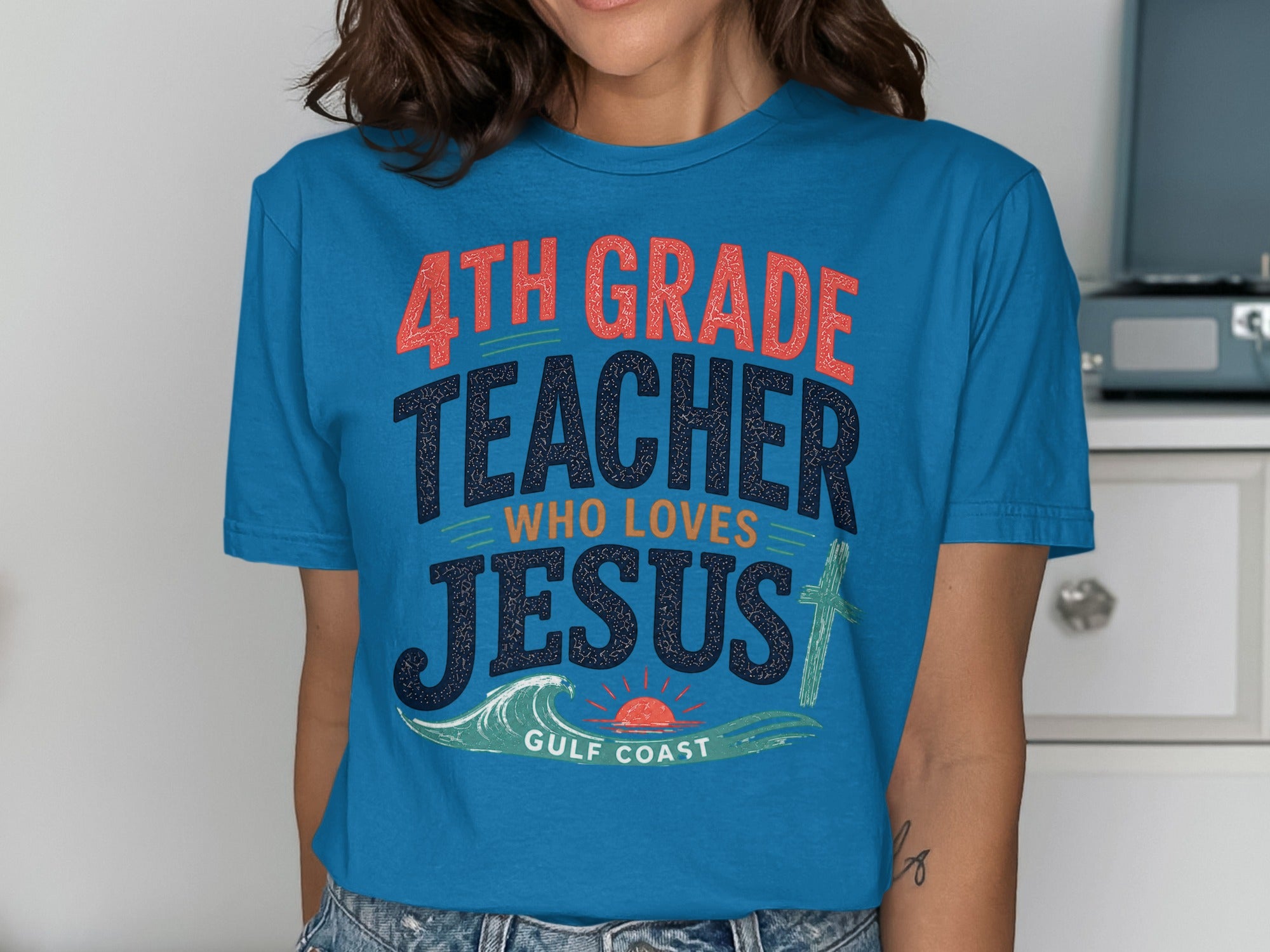 Teal t-shirt with "4th Grade Teacher Who Loves Jesus" and a cross.