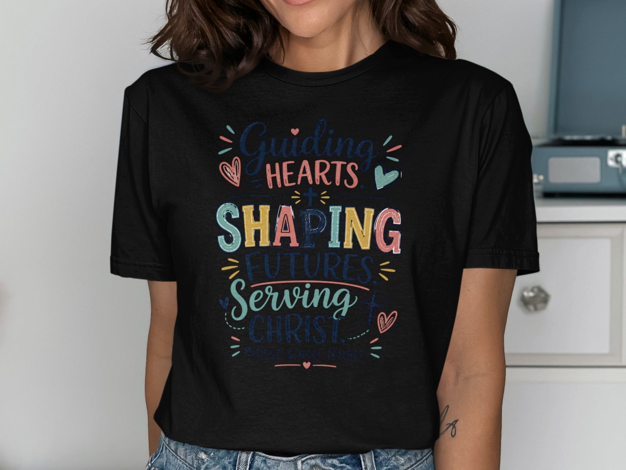 Black t-shirt with "Guiding Hearts, Shaping Futures, Serving Christ" text.