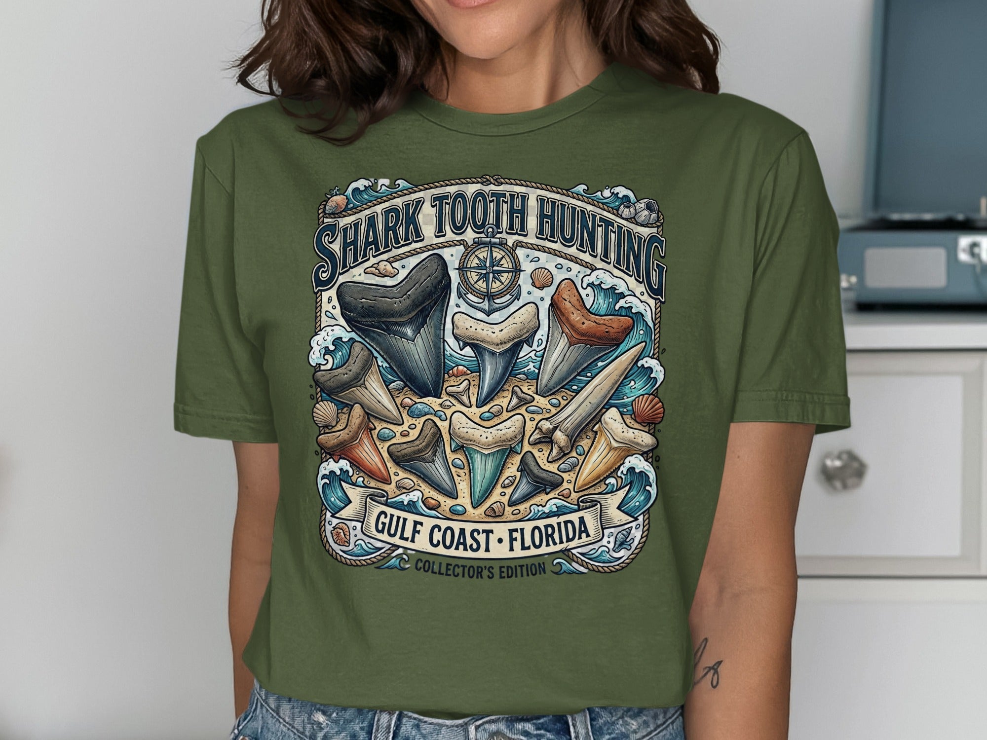 Green t-shirt with "Shark Tooth Hunting Gulf Coast Florida" and assorted shark teeth.