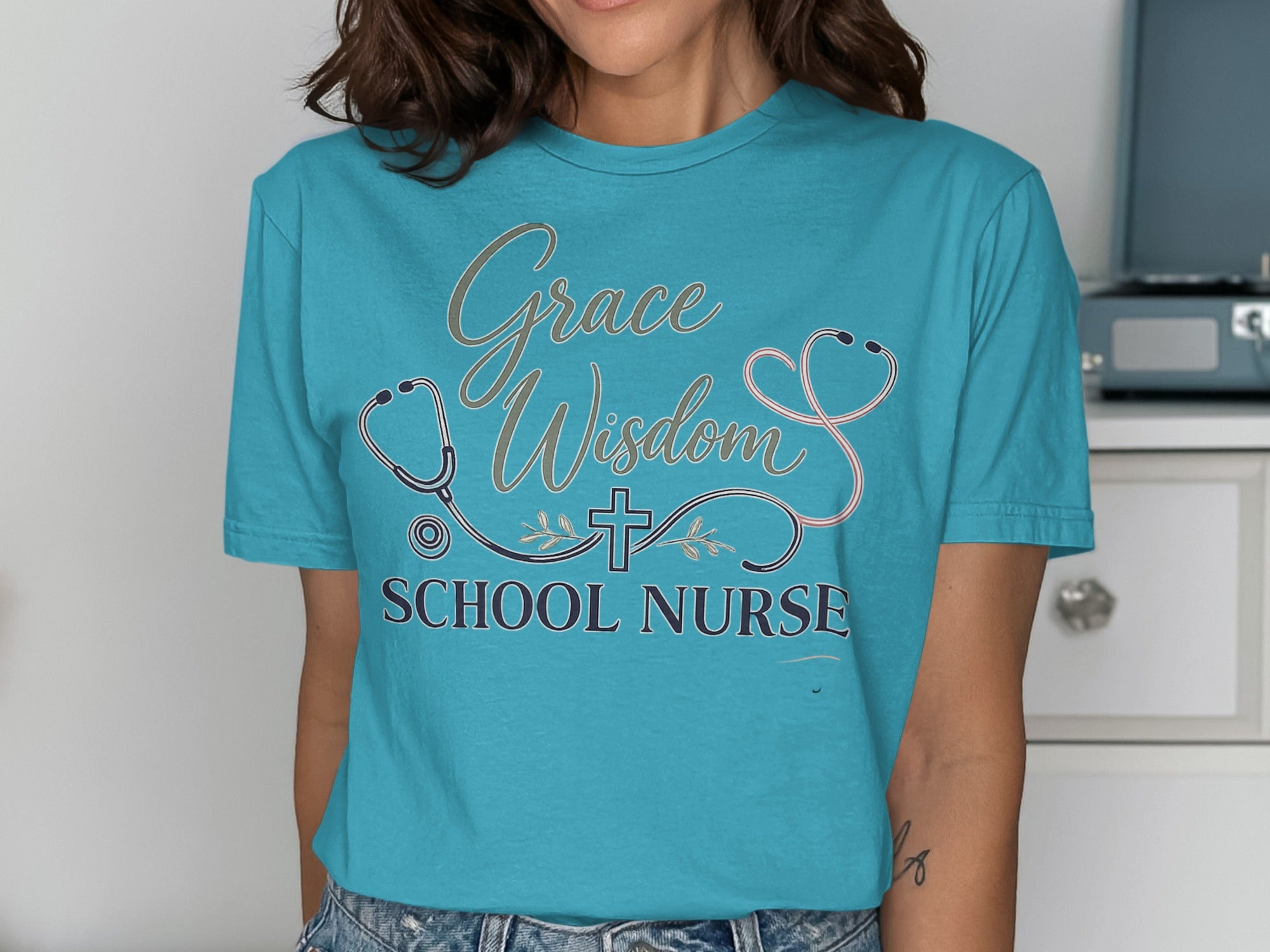 Teal t-shirt with "Grace Wisdom School Nurse" text and stethoscope design.