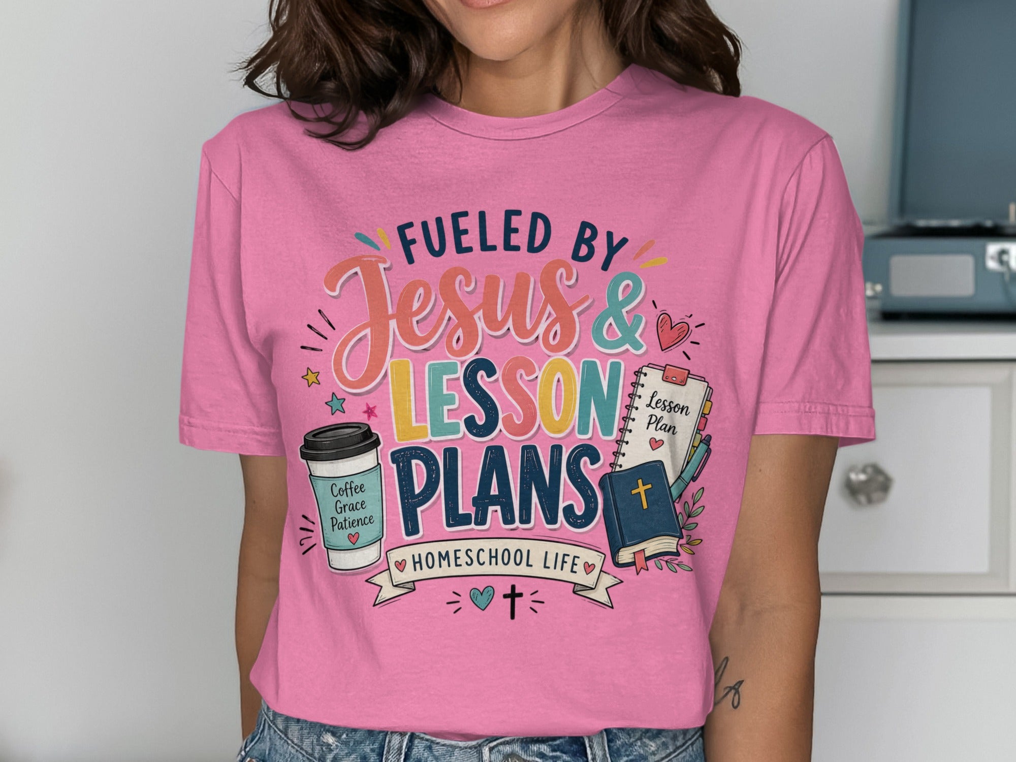 Pink t-shirt with "Fueled by Jesus & Lesson Plans" and homeschool graphics.