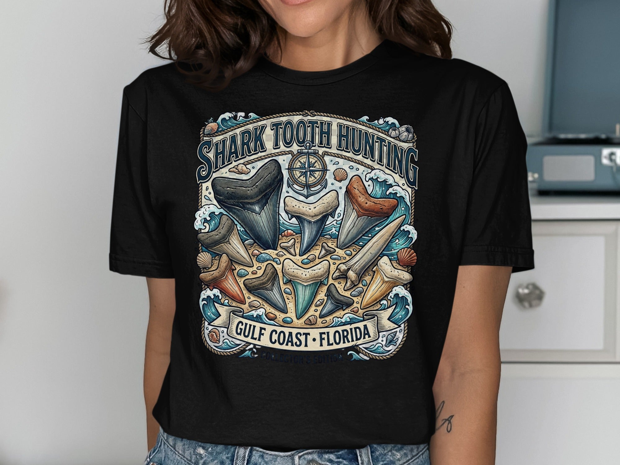 Shark tooth hunting graphic with text "GULF COAST FLORIDA" on black t-shirt.