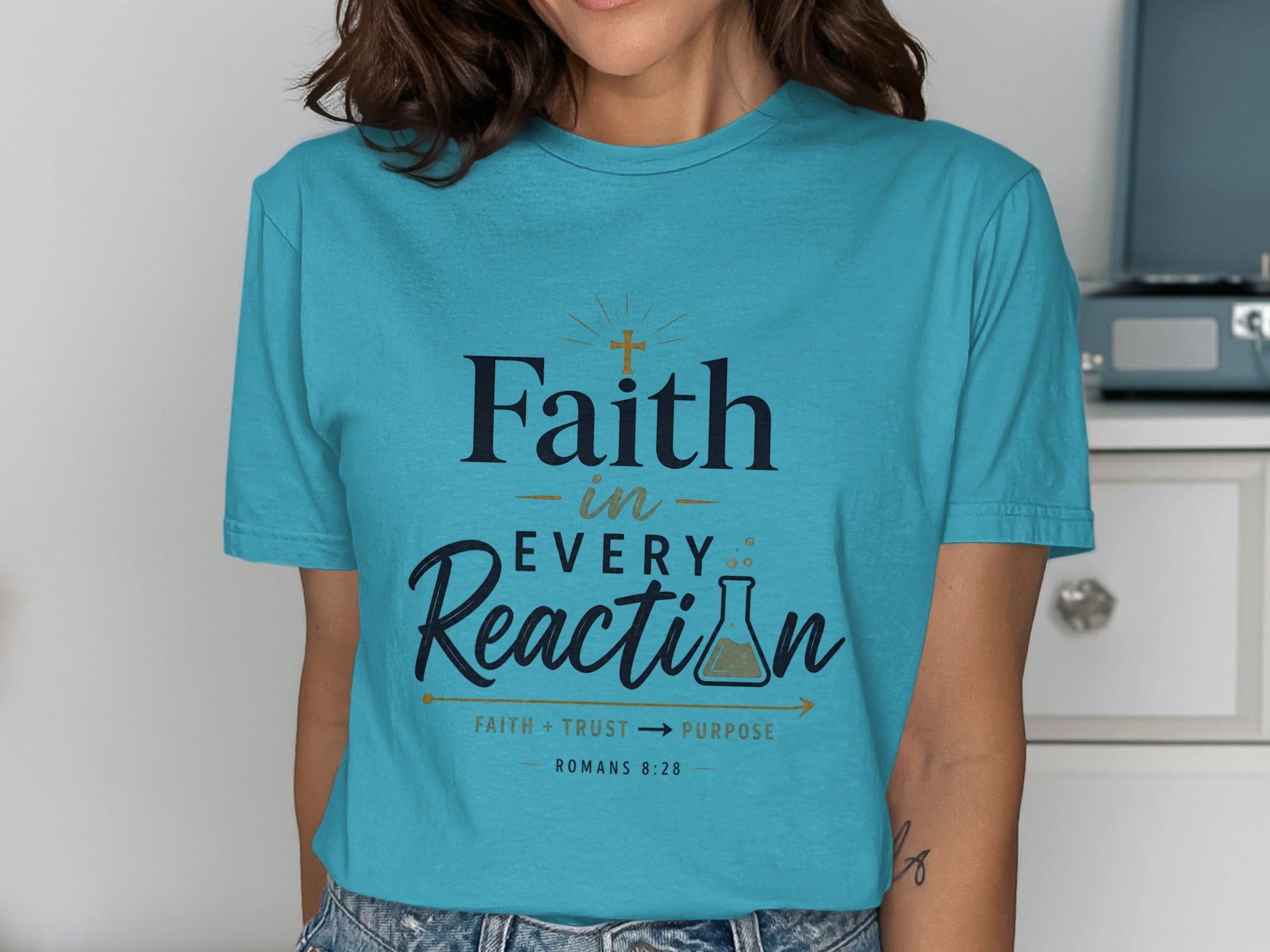 Turquoise t-shirt with "Faith in Every Reaction" and Romans 8:28.