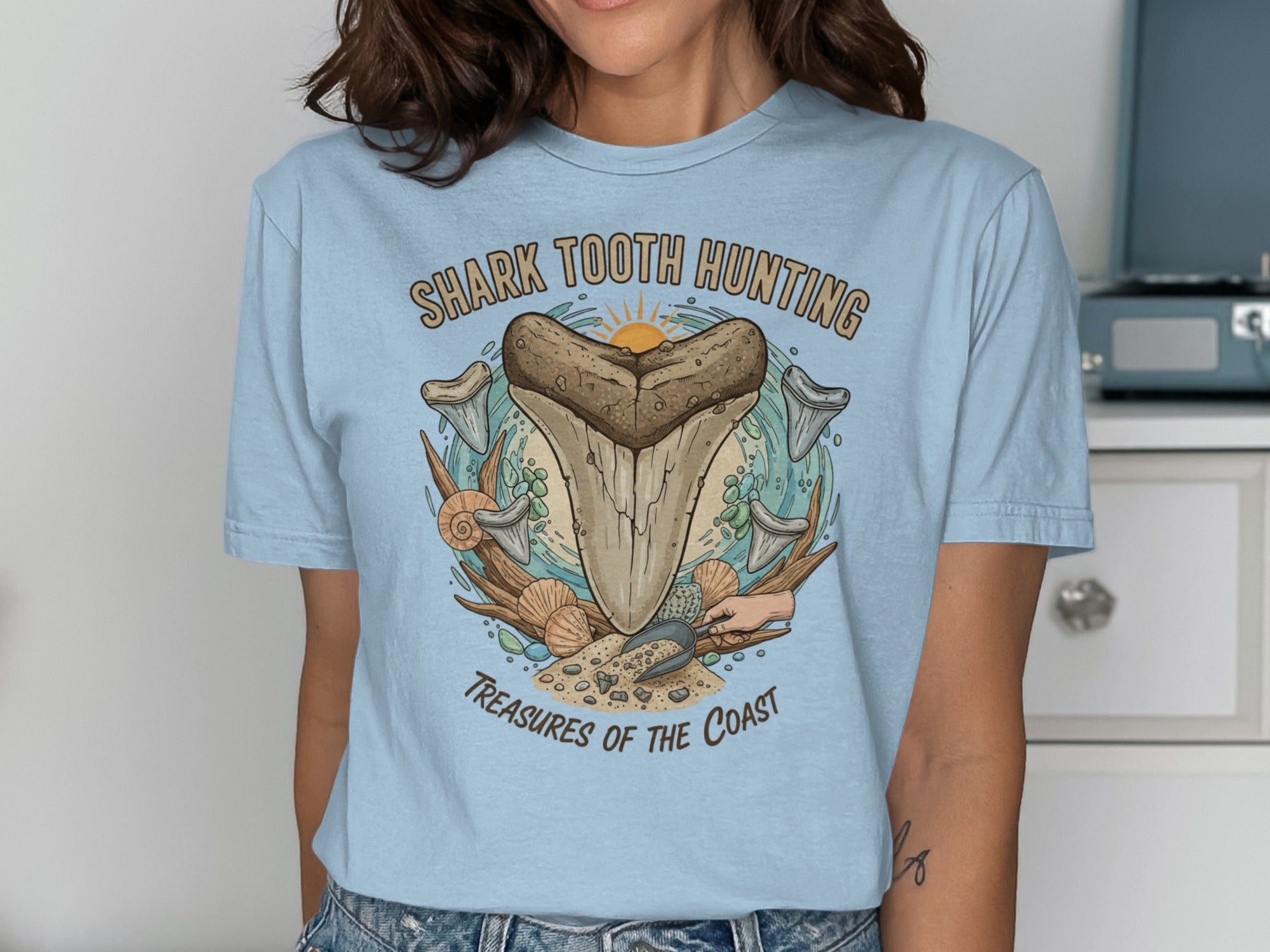 Light blue t-shirt with "Shark Tooth Hunting Treasures of the Coast" graphic.