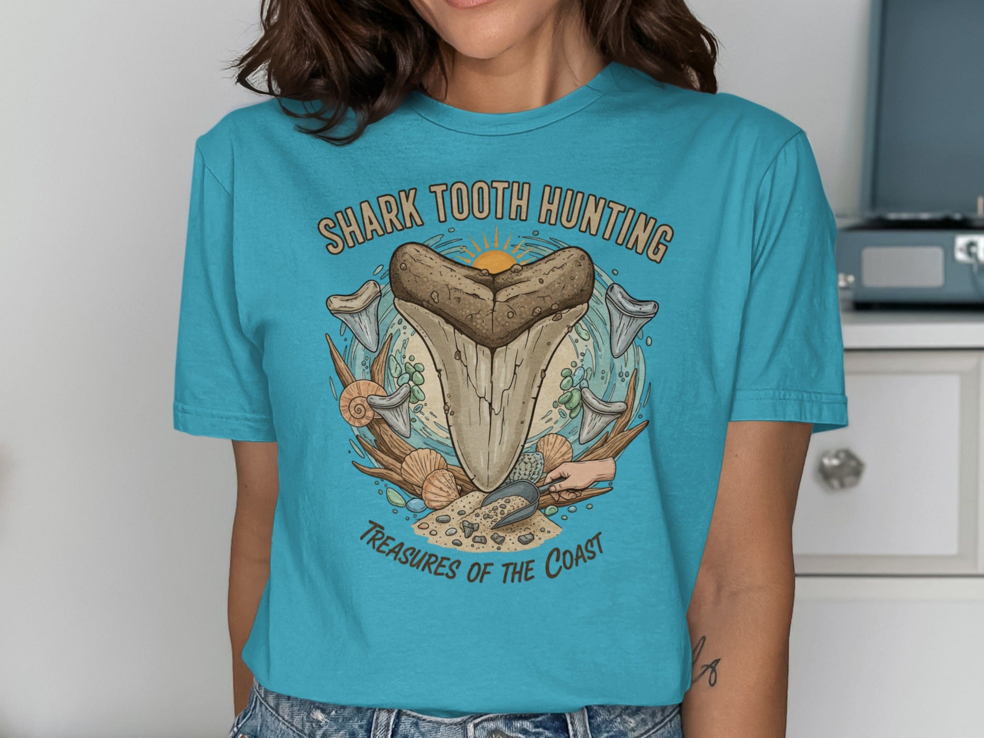 Teal t-shirt with "Shark Tooth Hunting" and "Treasures of the Coast" text.