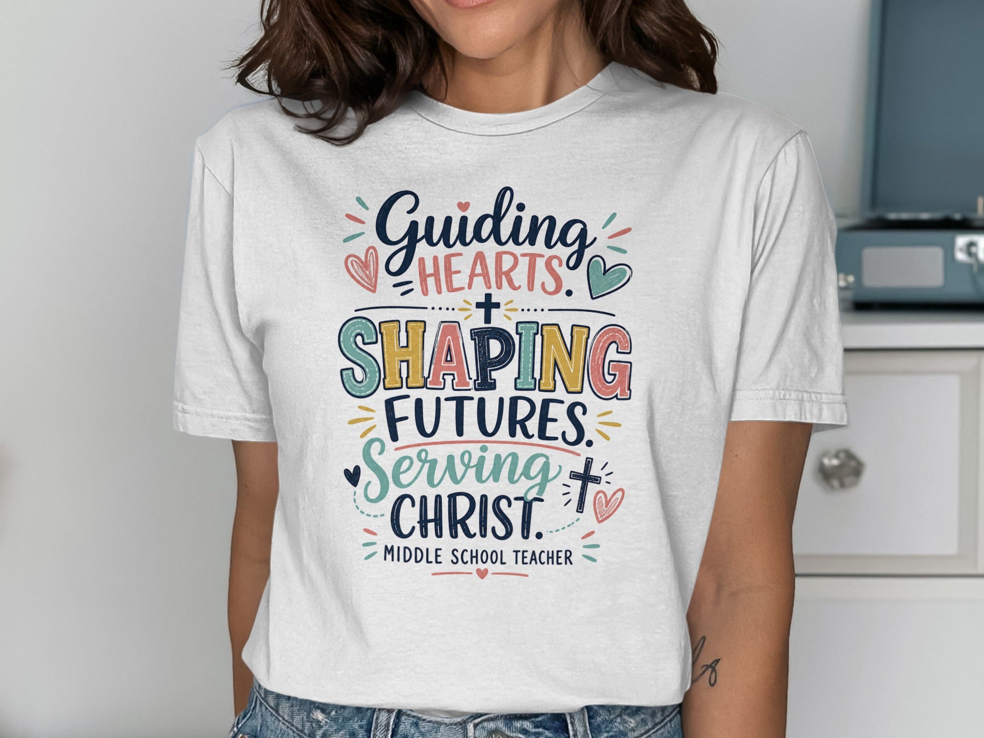 White t-shirt with colorful text: "Guiding Hearts, Shaping Futures, Serving Christ. Middle School Teacher."