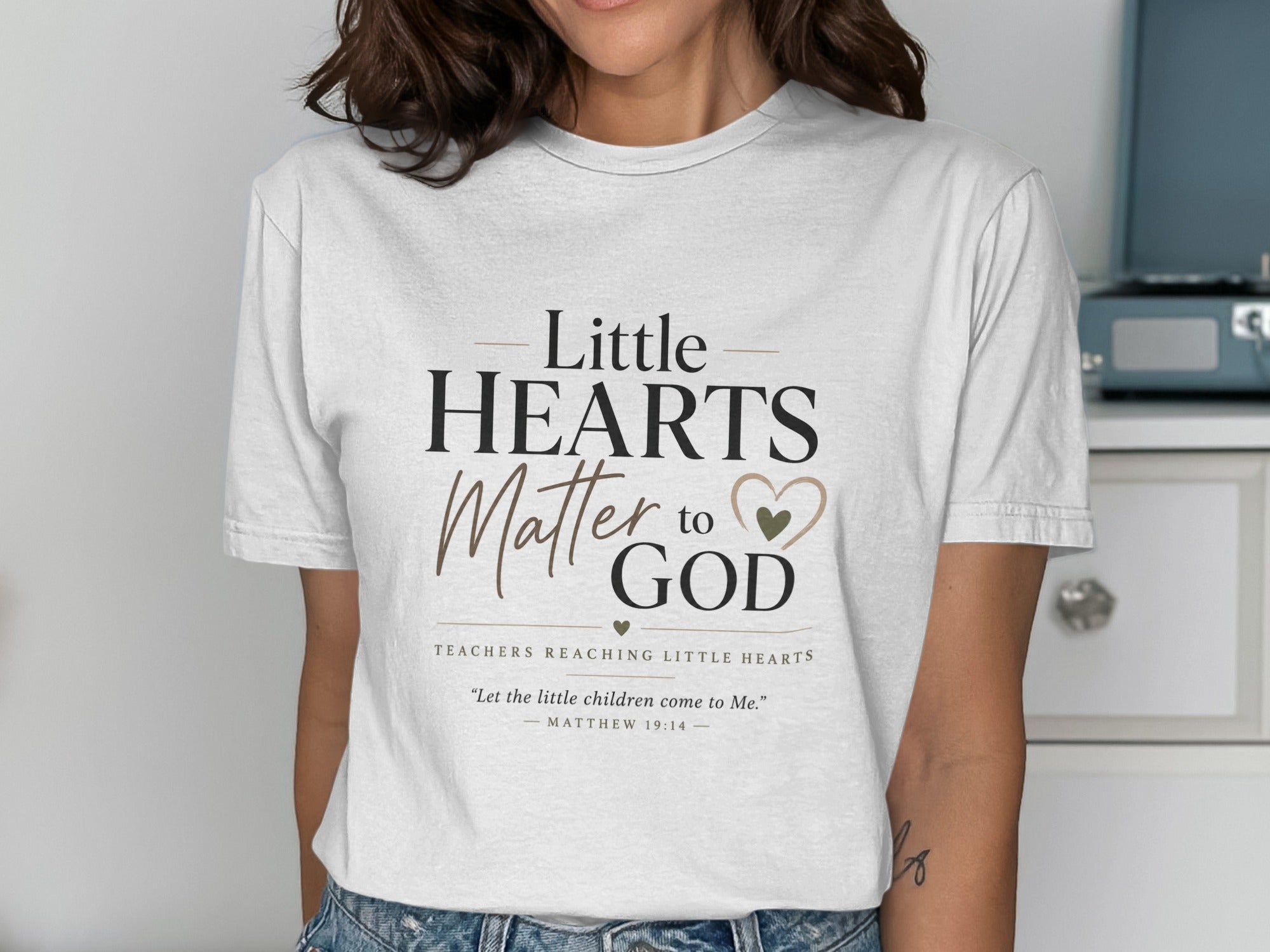 White t-shirt with "Little HEARTS Matter to GOD" and Matthew 19:14.