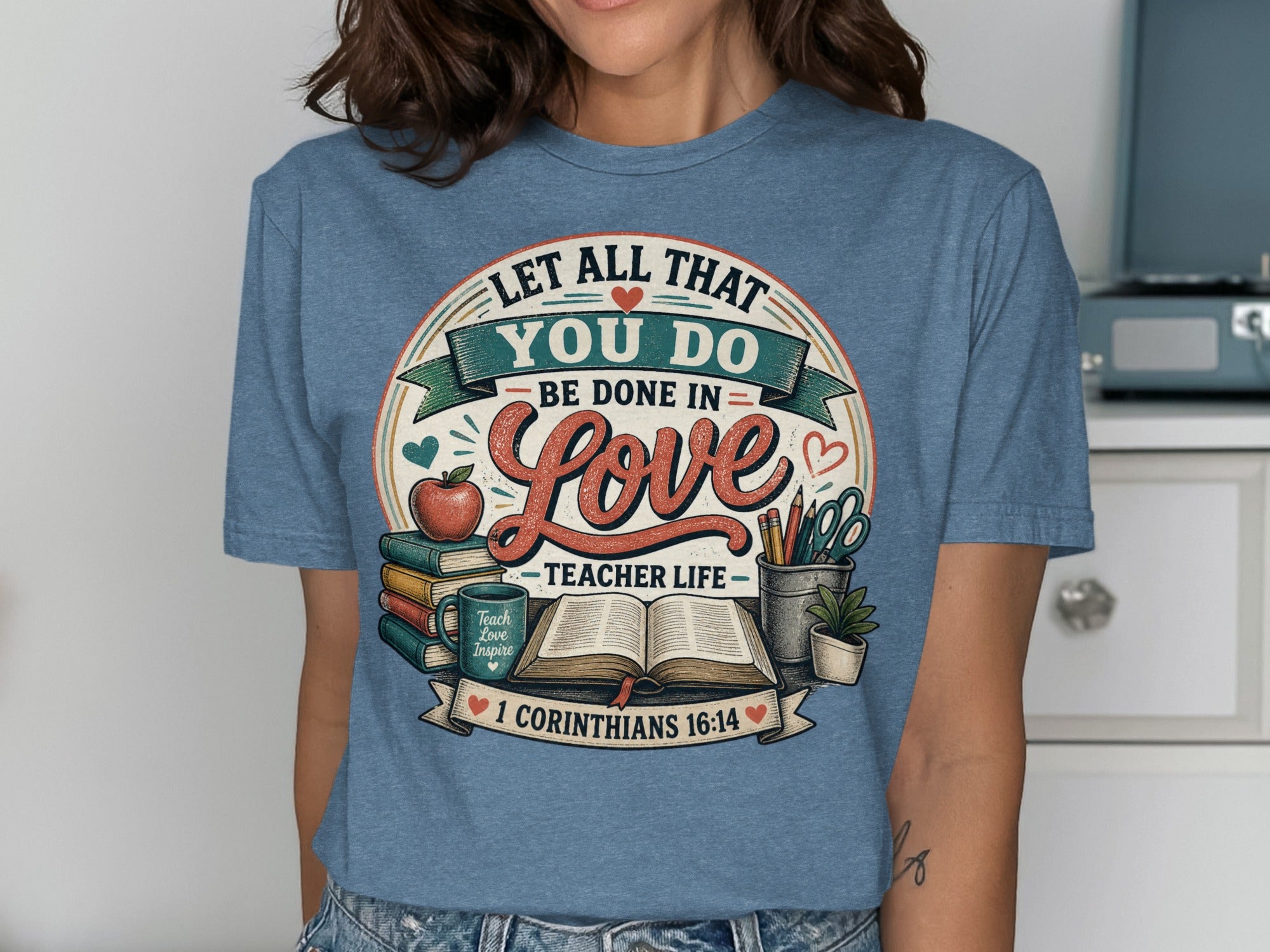 T-shirt with "Let All That You Do Be Done In Love" and teacher-themed graphics.
