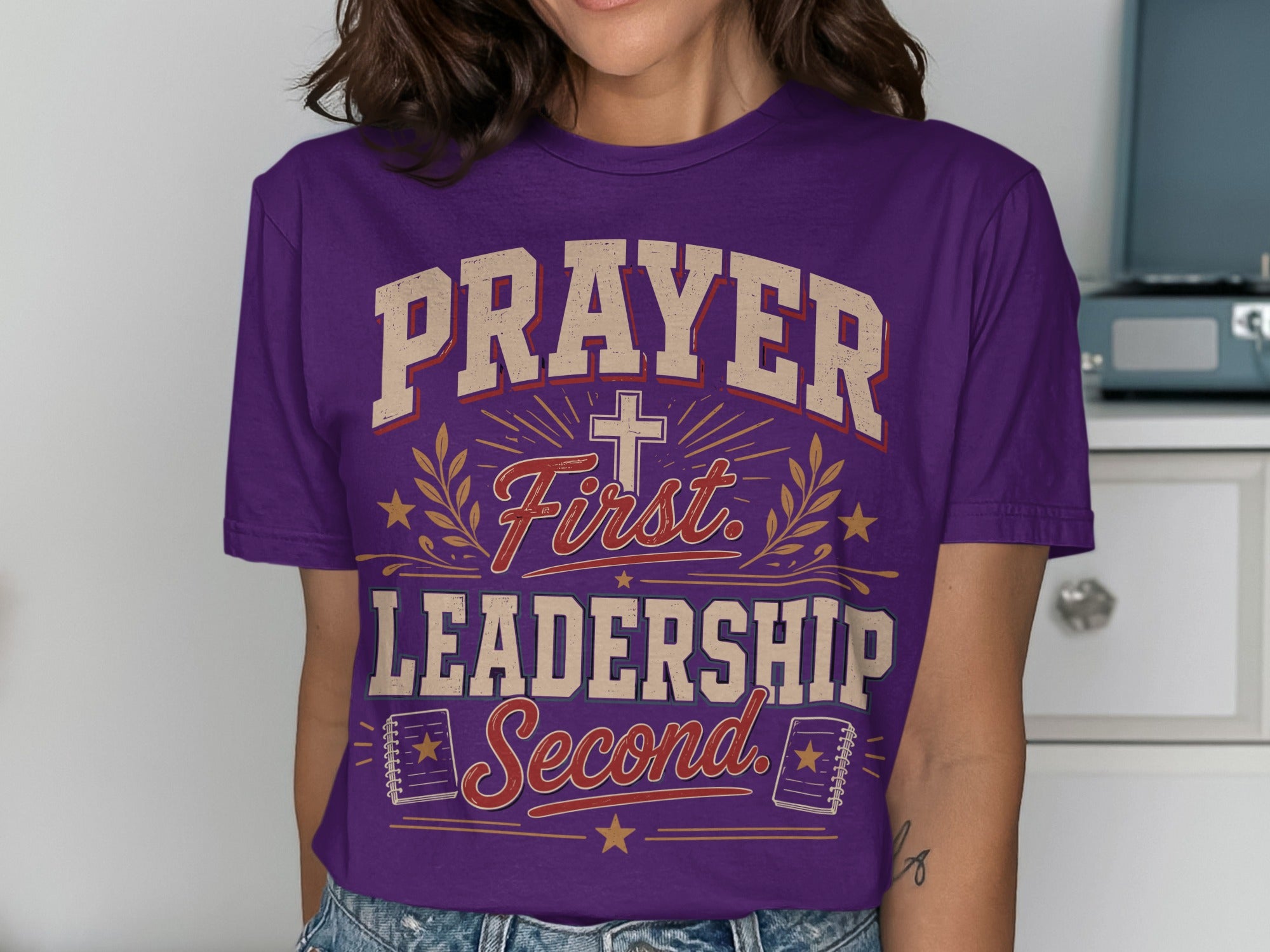 Purple t-shirt with "PRAYER FIRST LEADERSHIP SECOND" text and religious symbols.