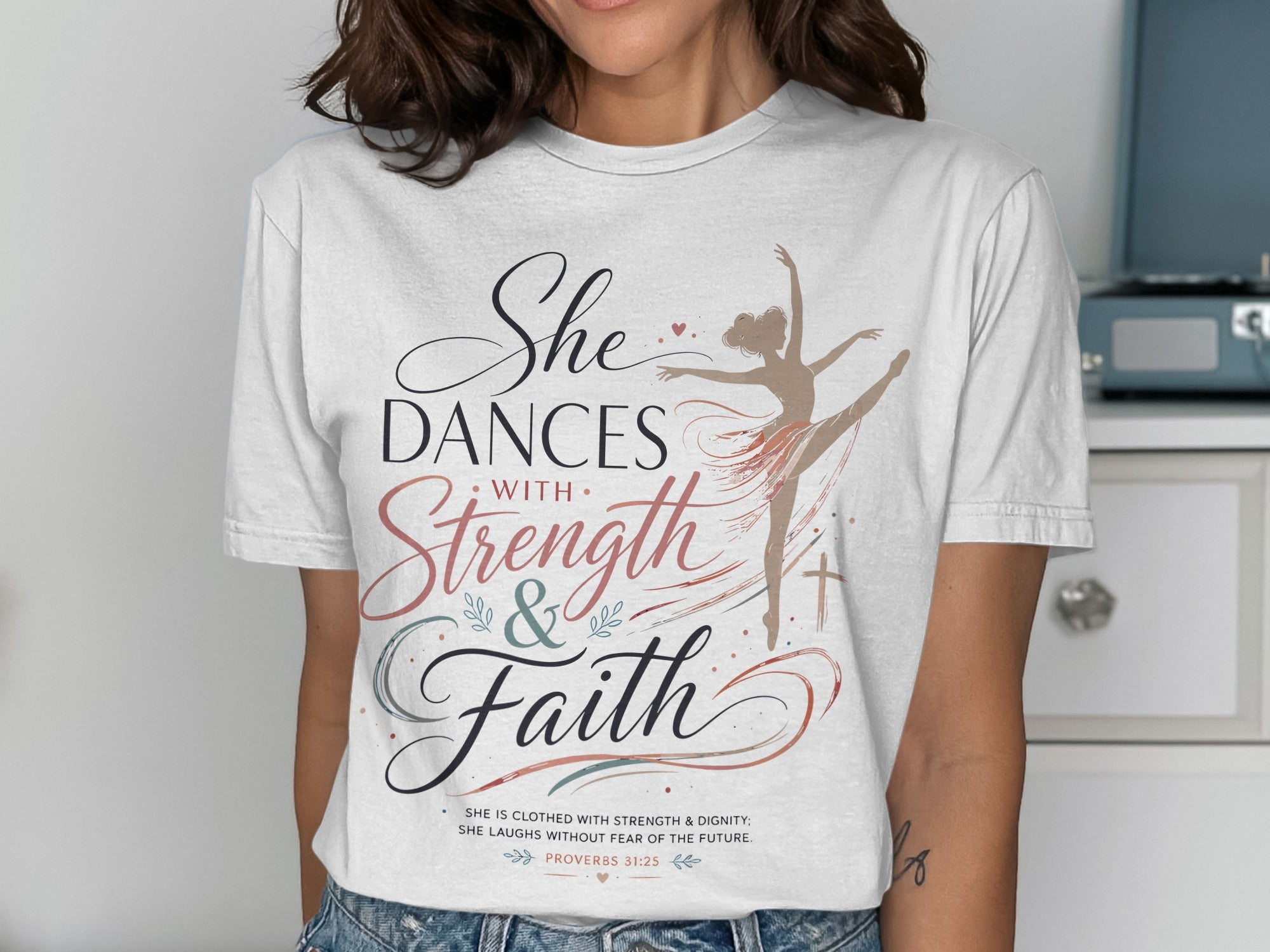 T-shirt with dancer graphic and "She Dances with Strength & Faith" text.