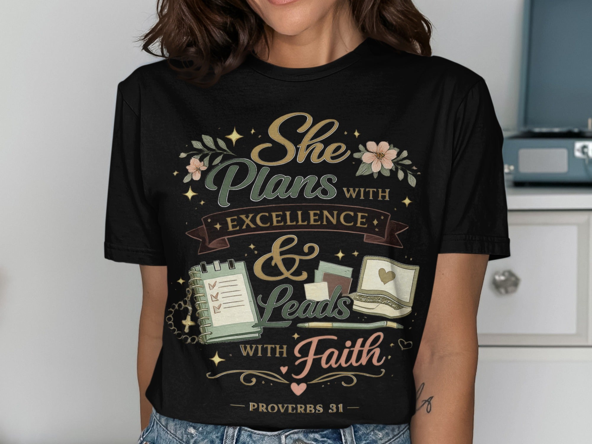 Black t-shirt with "She Plans with Excellence & Leads with Faith" text design.