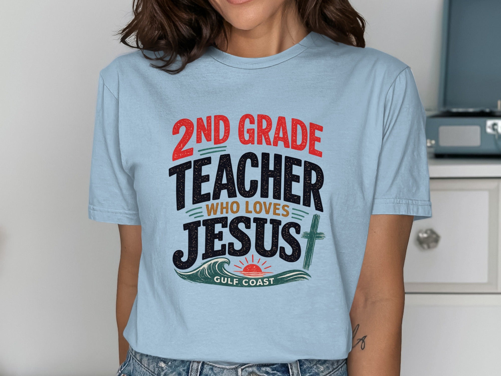 Light blue t-shirt with "2nd Grade Teacher Who Loves Jesus" and a wave graphic.