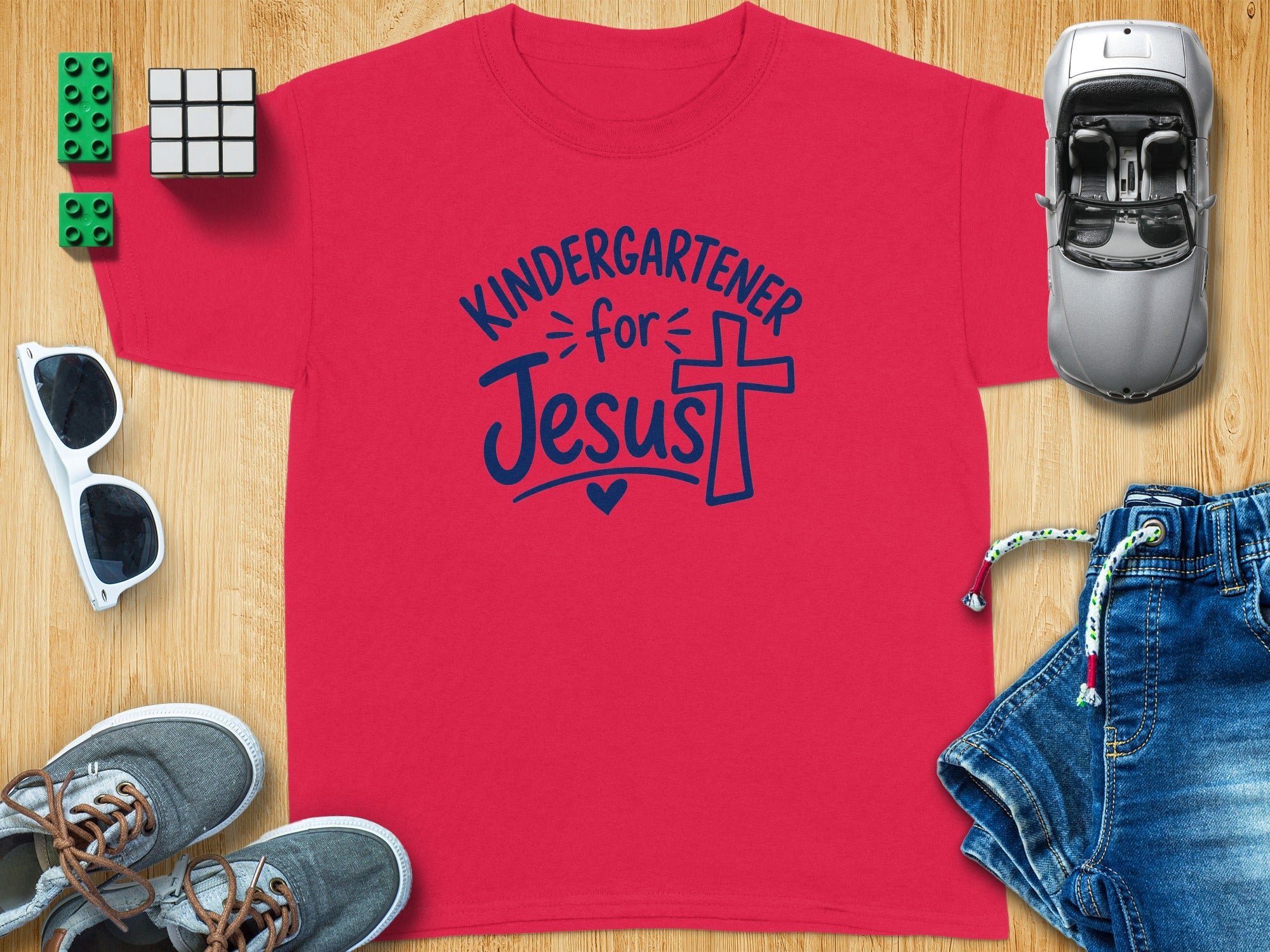 Red t-shirt with "Kindergartener for Jesus" text and a cross design.