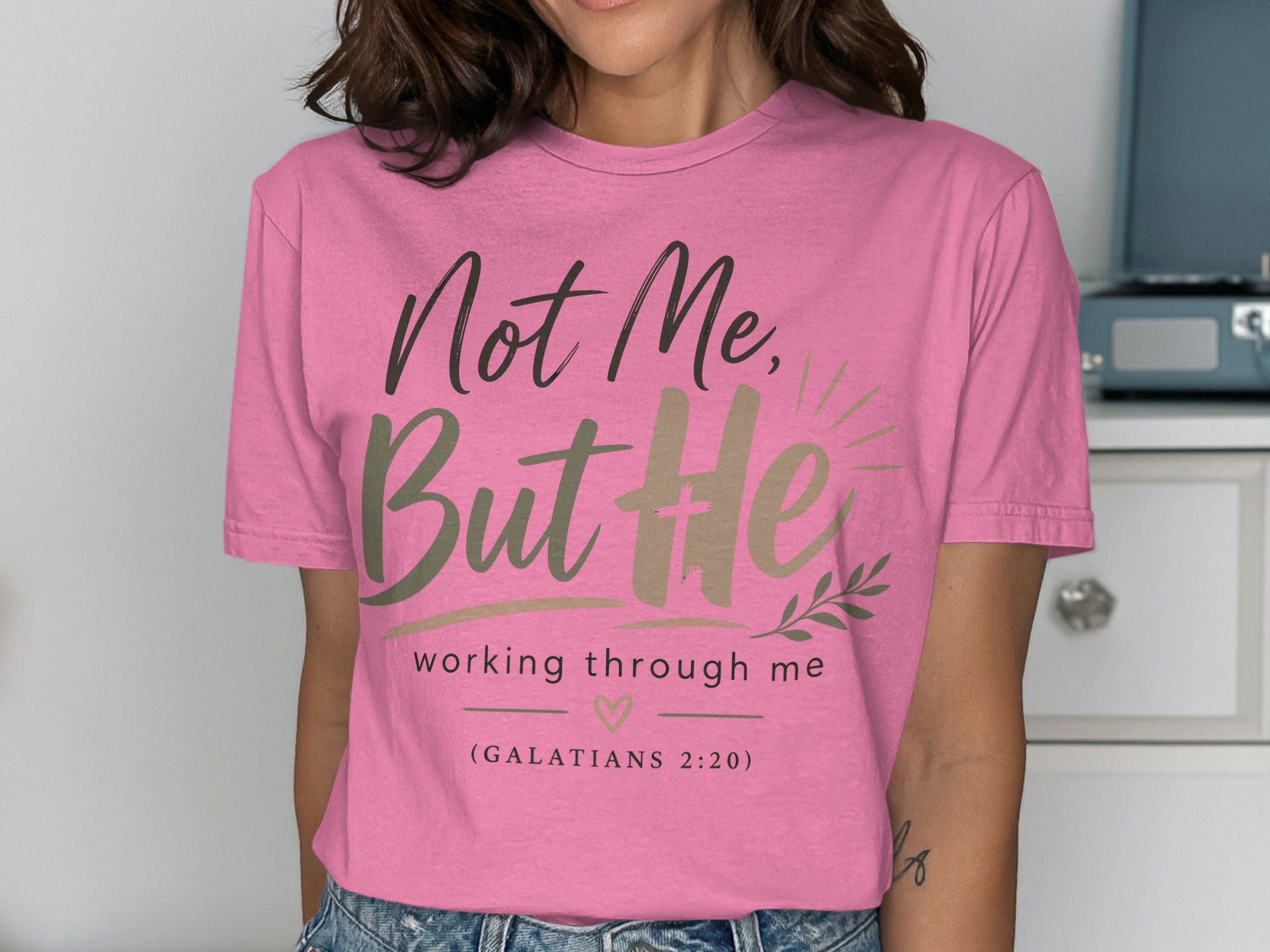 Pink t-shirt with "Not Me, But He working through me (GALATIANS 2:20)" text.
