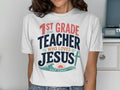 White t-shirt with "1st Grade Teacher Who Loves Jesus" text and ocean graphic.
