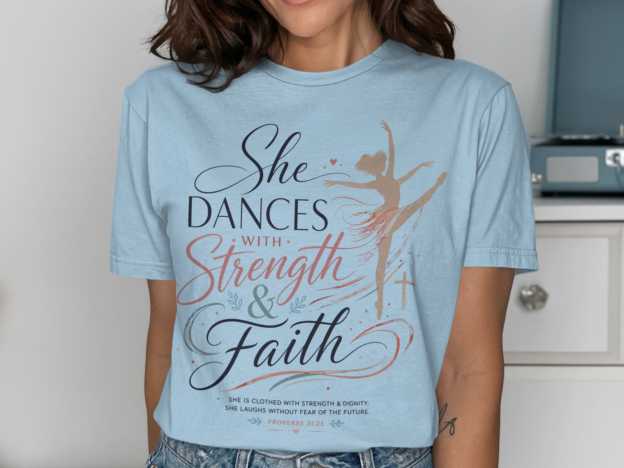 Light blue t-shirt with "She Dances with Strength & Faith" and Proverbs 31:25.