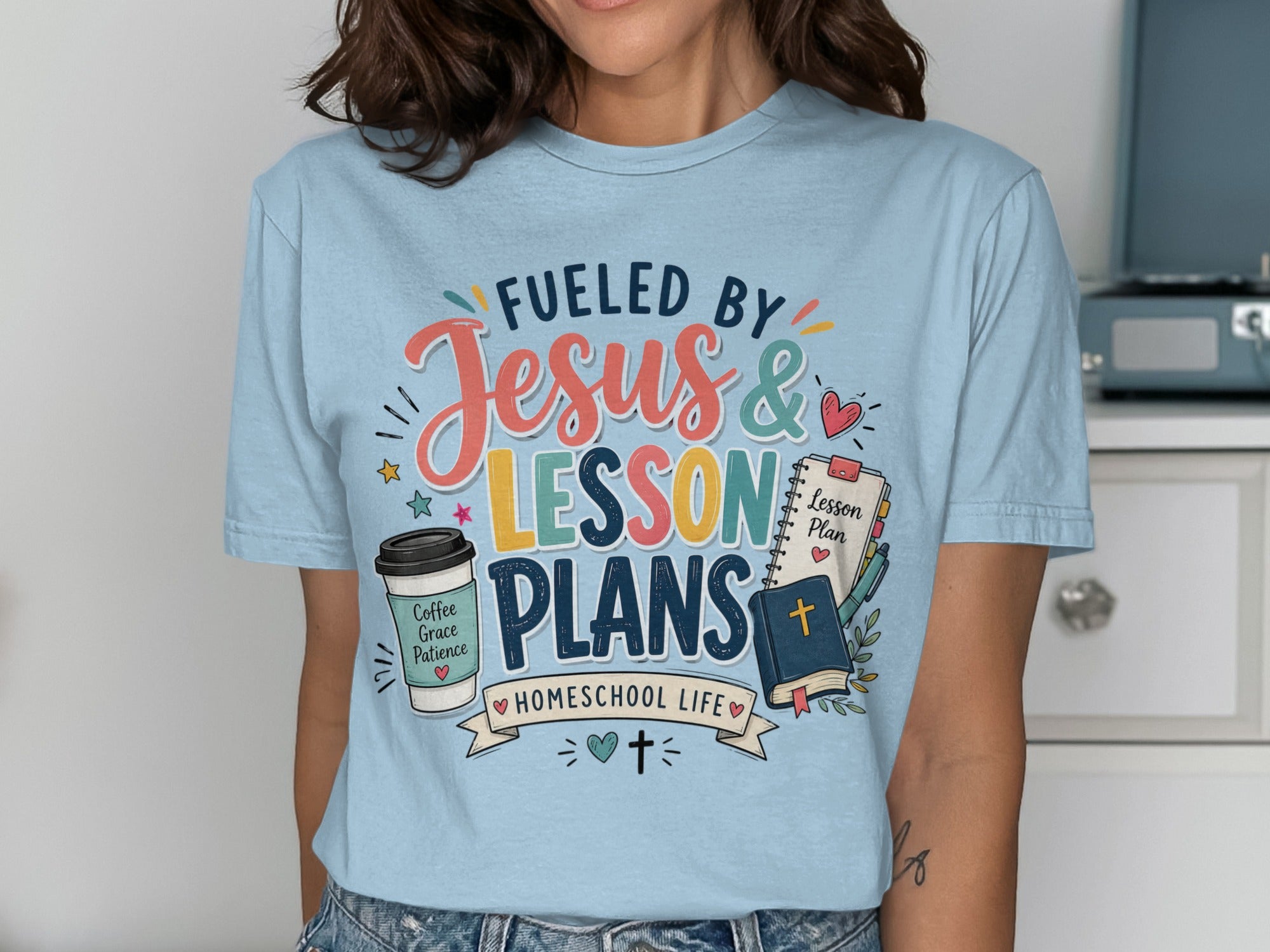 T-shirt with "Fueled by Jesus & Lesson Plans Homeschool Life" text and icons.