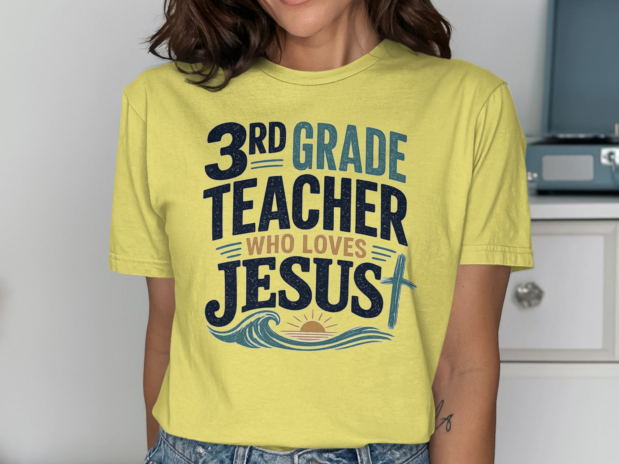 Yellow t-shirt with "3rd grade teacher who loves Jesus" and a cross.