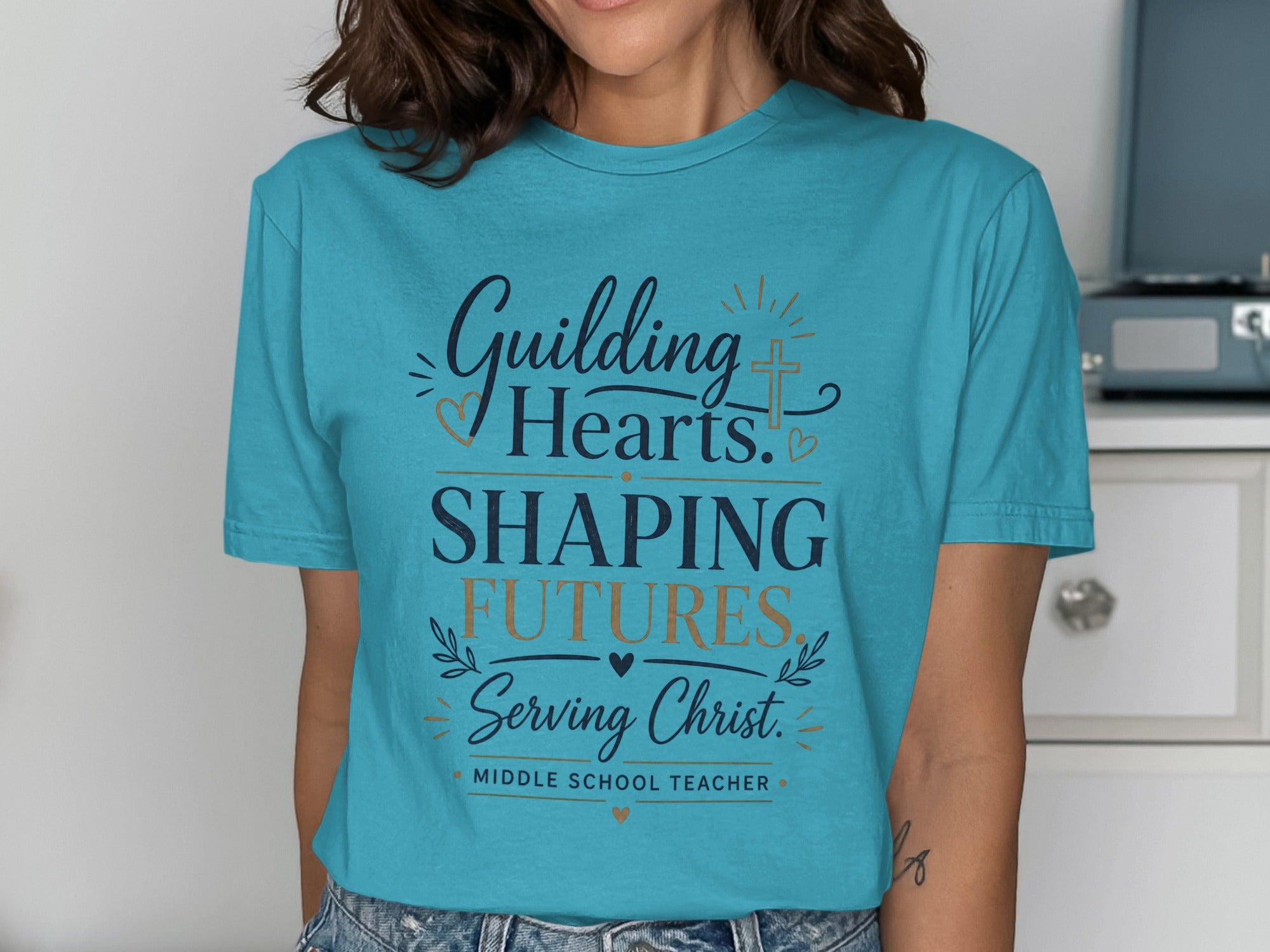 Teal t-shirt with "Guiding Hearts, Shaping Futures, Serving Christ. Middle School Teacher." text.