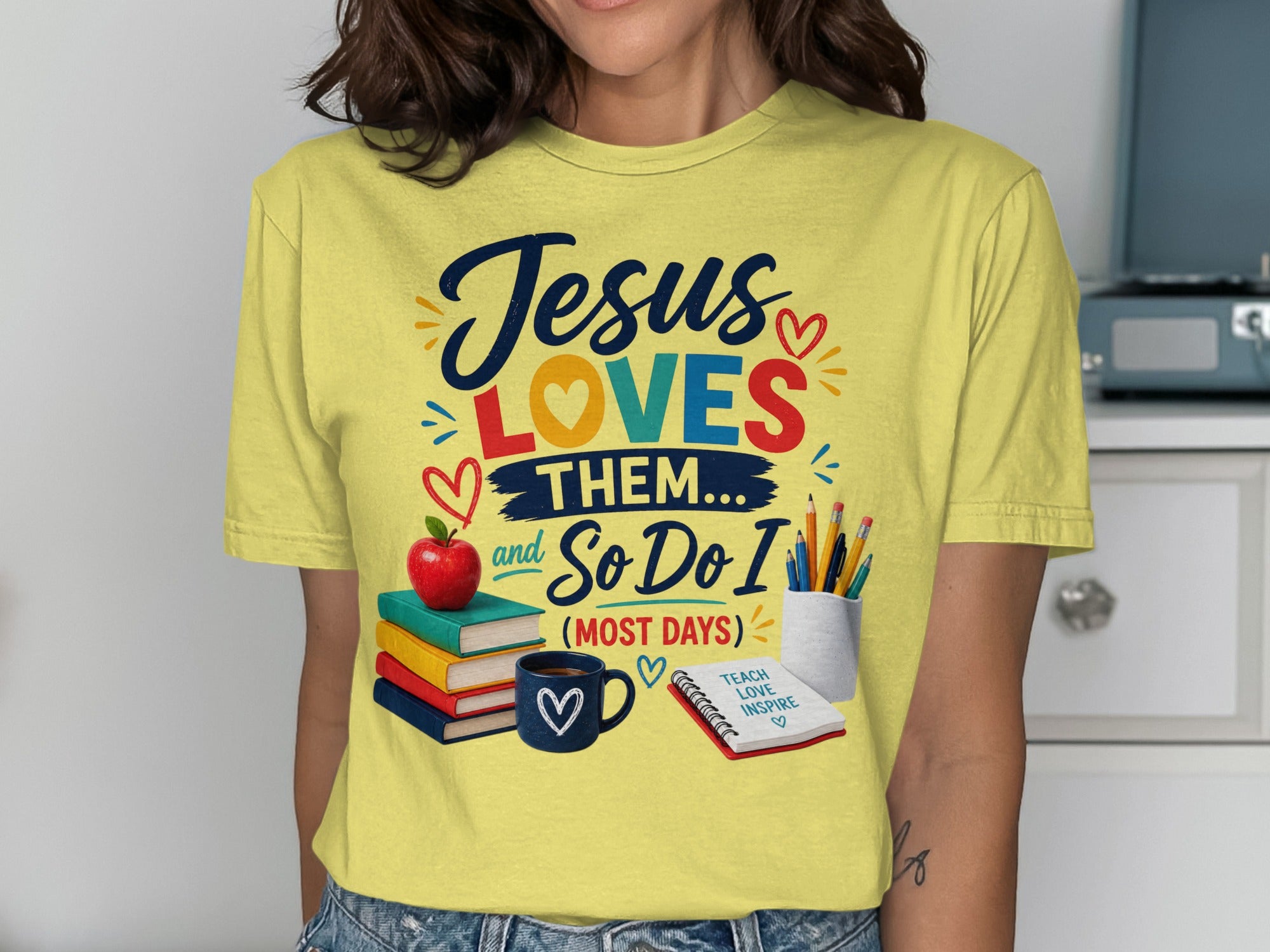 Yellow t-shirt with "Jesus Loves Them... And So Do I" text and school supplies.