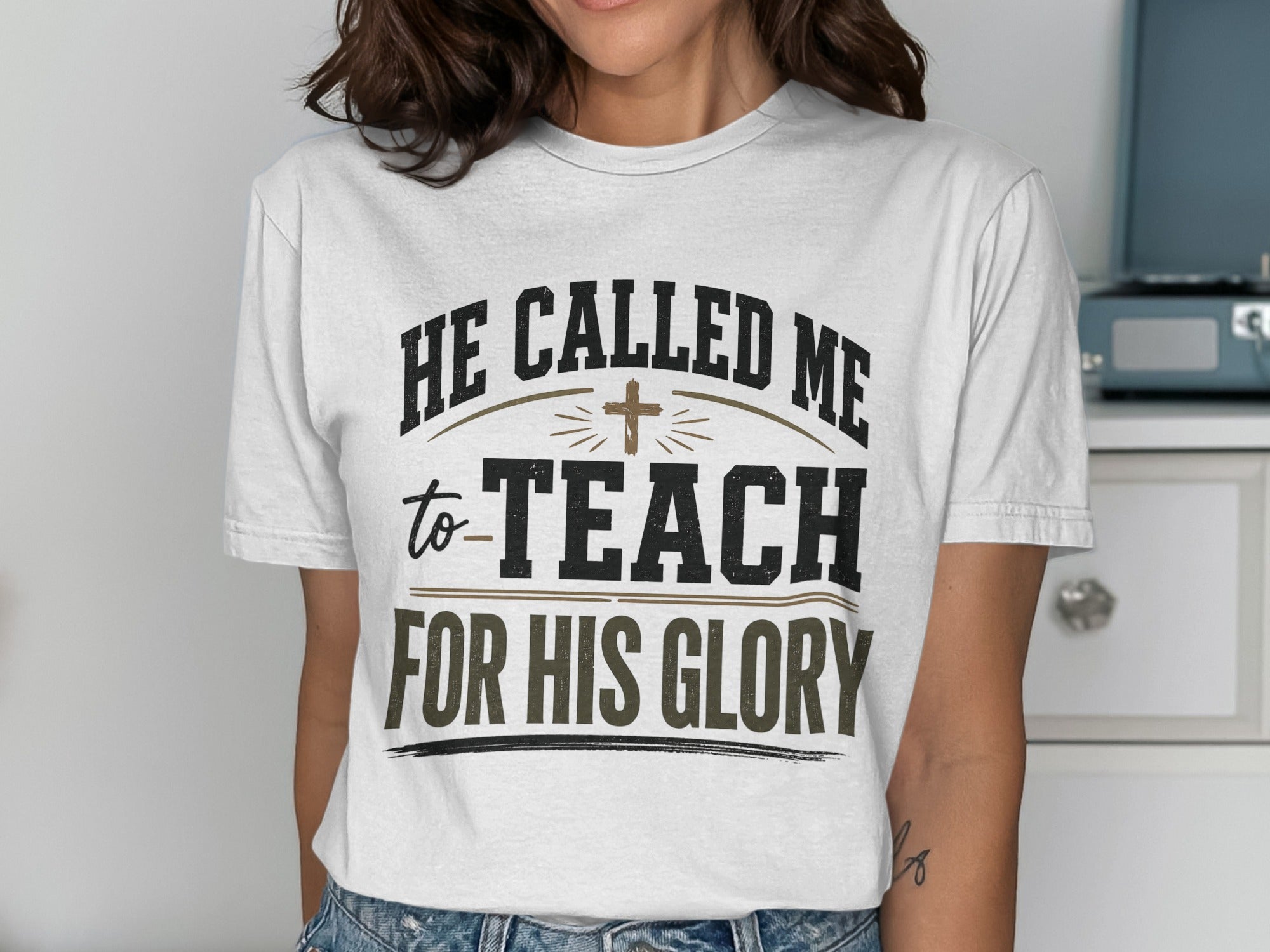 White t-shirt with "He called me to teach for His glory" text and cross.