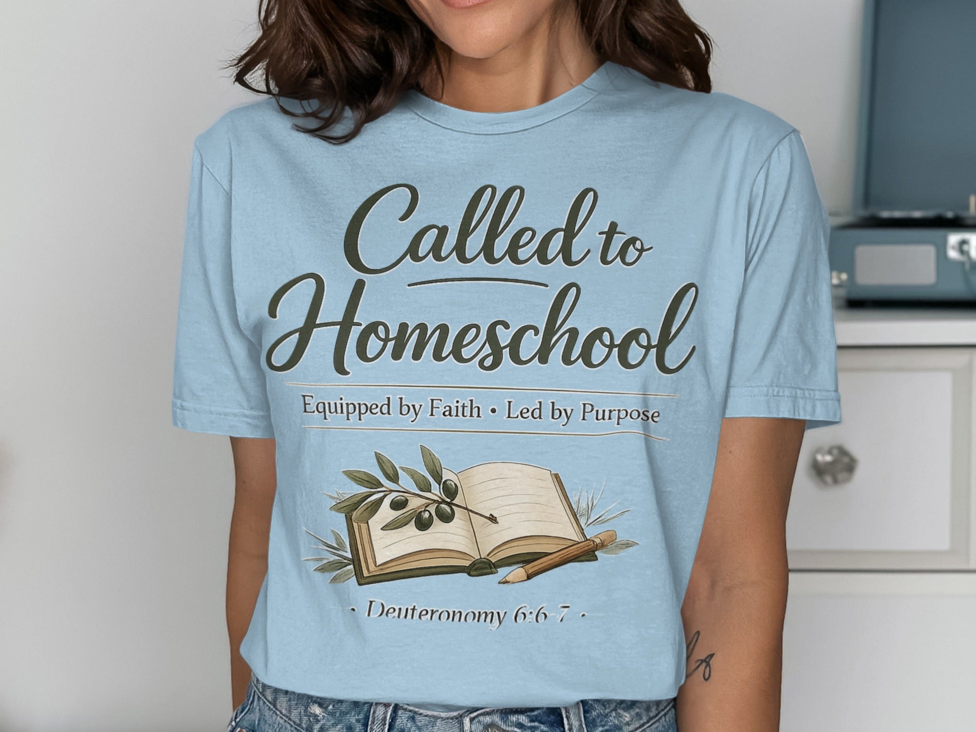 Light blue t-shirt with "Called to Homeschool" text, an open book, and olive branches.