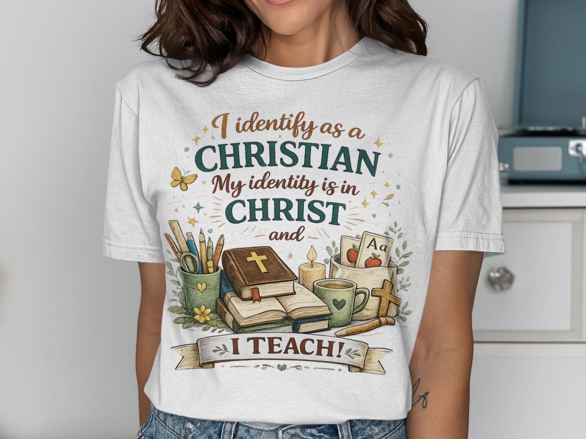 White t-shirt with "I identify as a CHRISTIAN My identity is in CHRIST and I TEACH!" text and religious icons.