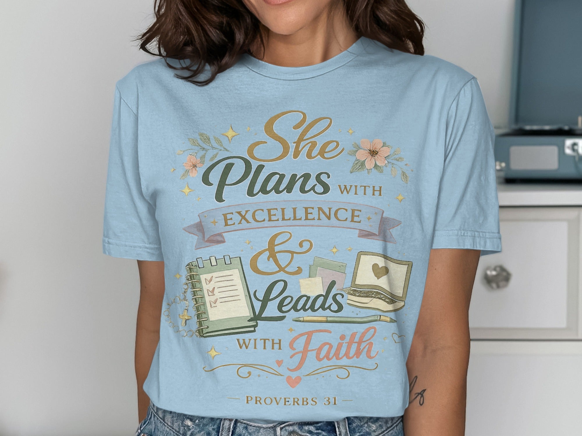 Light blue t-shirt with "She Plans with Excellence & Leads with Faith" Proverbs 31.