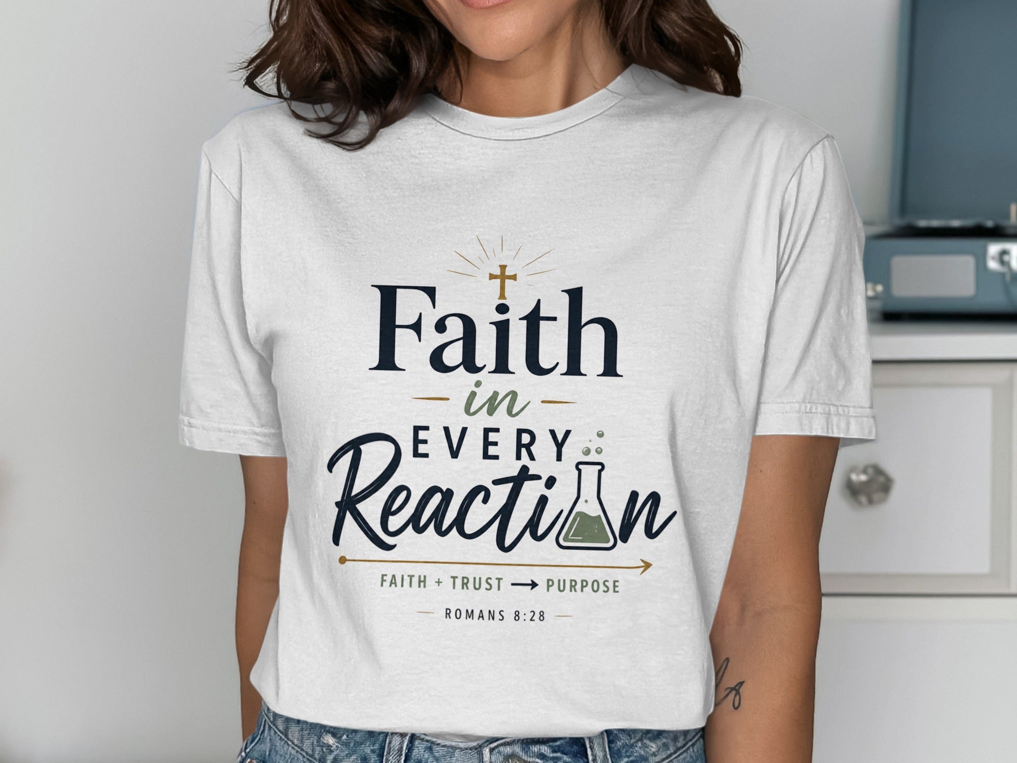 White t-shirt with "Faith in Every Reaction" and Romans 8:28.