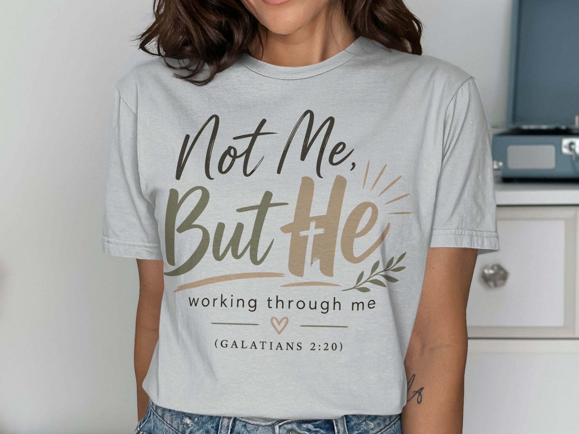 Grey t-shirt with "Not Me, But He" and "working through me" text, with Bible verse.