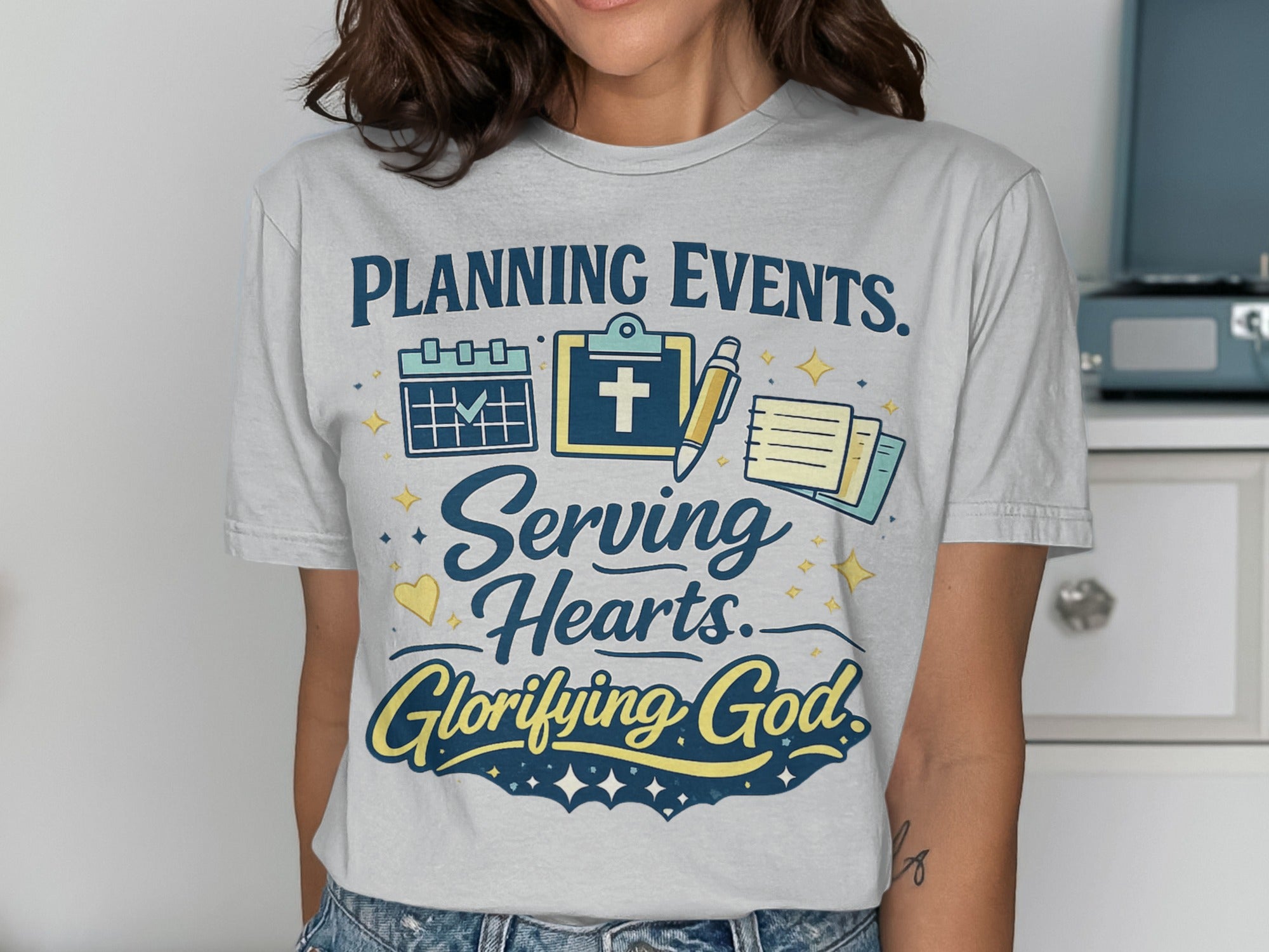 T-shirt with "Planning Events. Serving Hearts. Glorifying God." text and icons.