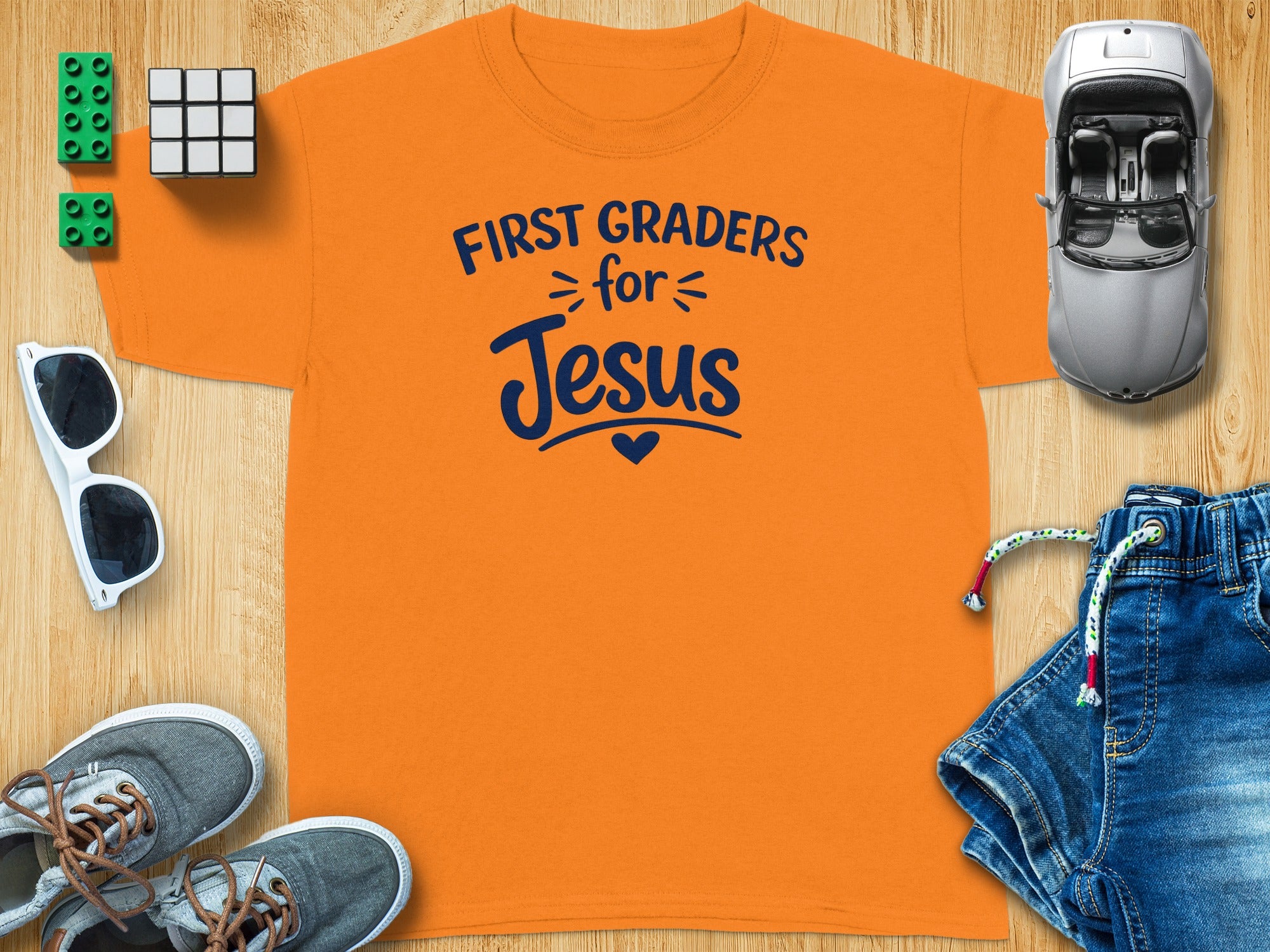 Orange t-shirt with "First Graders for Jesus" text and toys.
