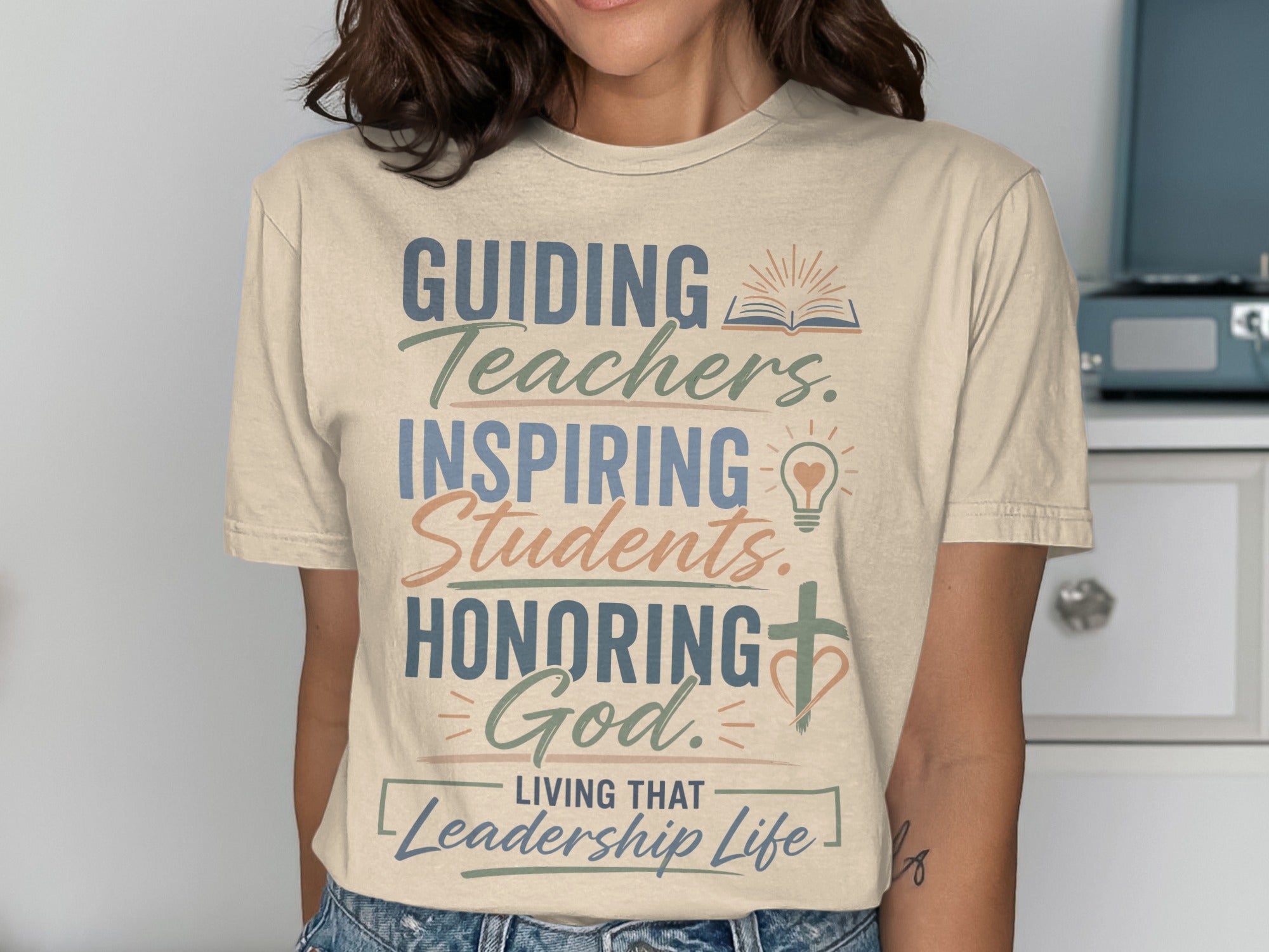 T-shirt with "Guiding Teachers, Inspiring Students, Honoring God, Living That Leadership Life" text.