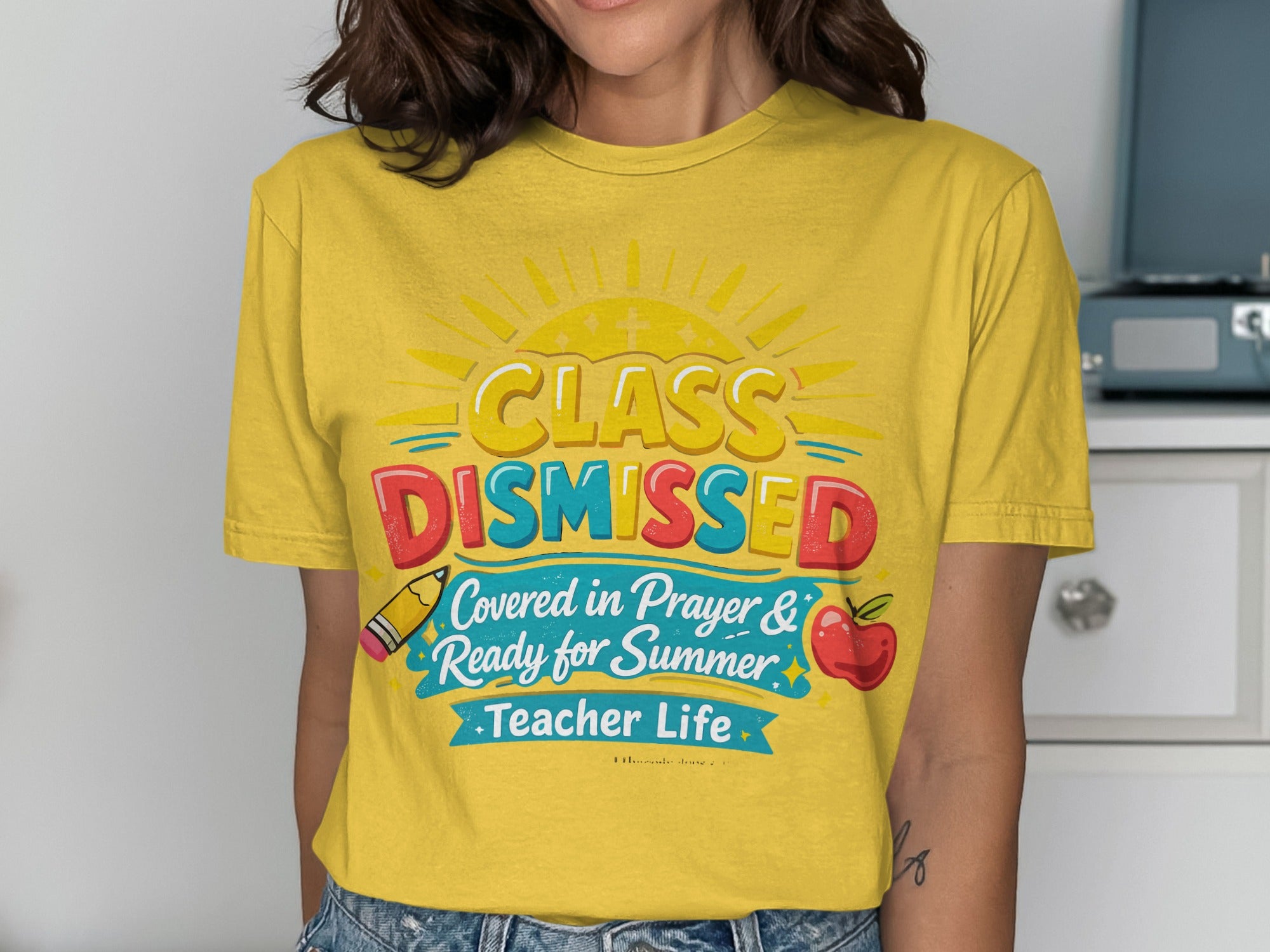 Yellow t-shirt with "Class Dismissed" and apple, pencil, and sun graphics.