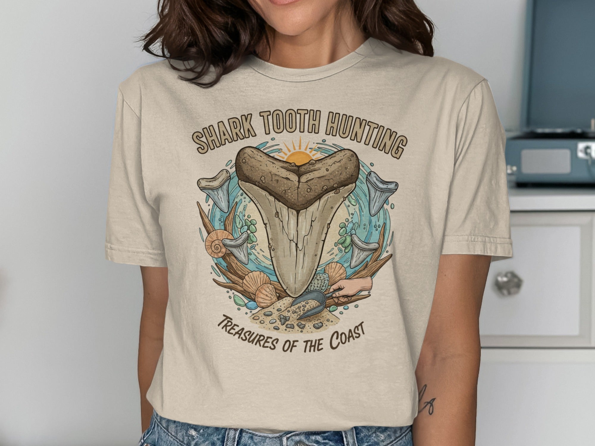 Cream t-shirt with "Shark Tooth Hunting Treasures of the Coast" graphic.
